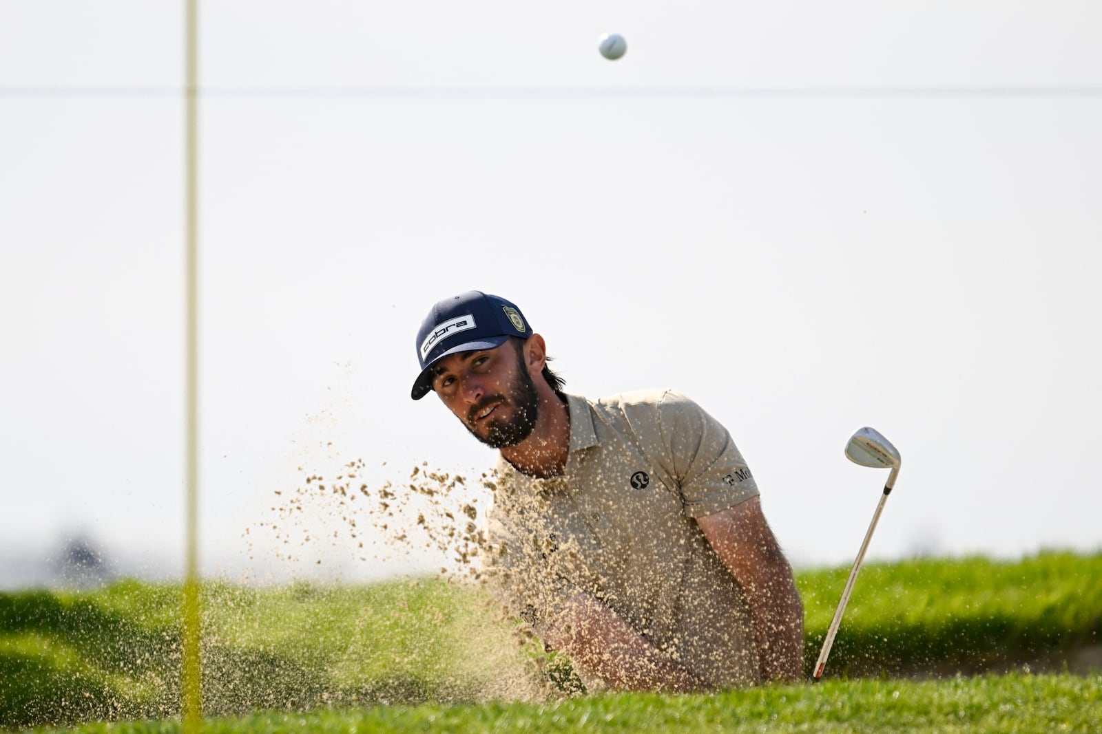 Max Homa hits out of the bunker on the first hole of the South Course at Torrey Pines during the first round of the Farmers Insurance Open golf tournament, Wednesday, Jan. 22, 2025, in San Diego. (AP Photo/Denis Poroy)