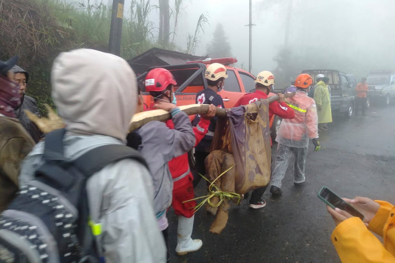 In this photo released by Indonesia's National Disaster Management Agency (BNPB), rescuers carry the body of a victim of flash flood in Pekalongan, Central Java, Indonesia on Tuesday, Jan. 21, 2025. (BNPB via AP)