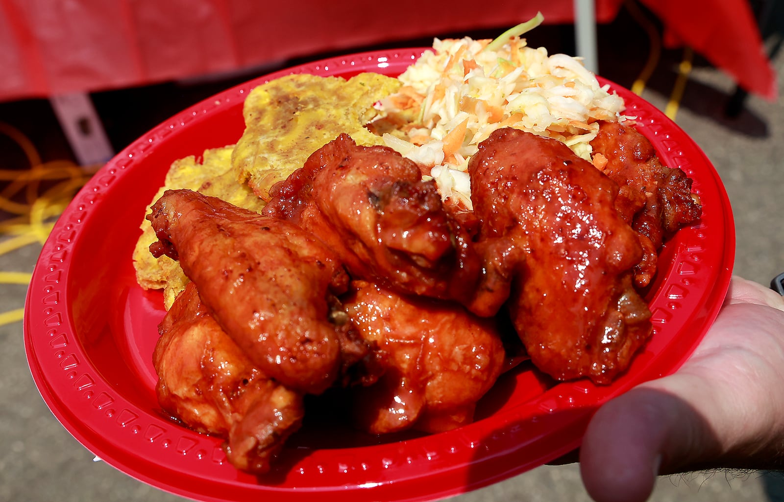 A plate of food, chicken wings, fried plantains and spicy slaw, served up at the Haitian Flag Day Festival Thursday, May 18, 2023 in Veterans Park. BILL LACKEY/STAFF