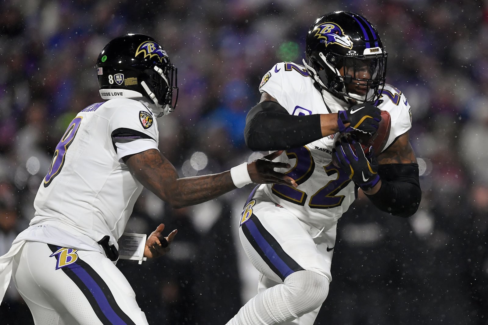 Baltimore Ravens quarterback Lamar Jackson (8) hands off the ball to running back Derrick Henry (22) during the first quarter of an NFL divisional playoff football game against the Buffalo Bills, Sunday, Jan. 19, 2025, in Orchard Park, N.Y. (AP Photo/Adrian Kraus)