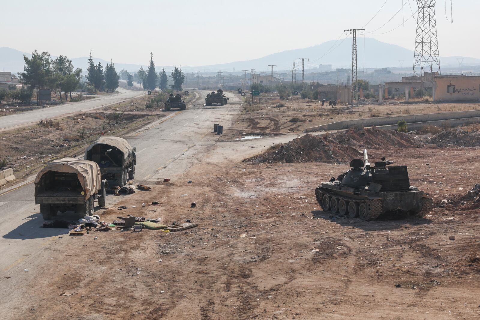 Abandoned Syrian army vehicles sit on a road in the outskirts of Hama, Syria, Tuesday Dec. 3, 2024.(AP Photo/Ghaith Alsayed)