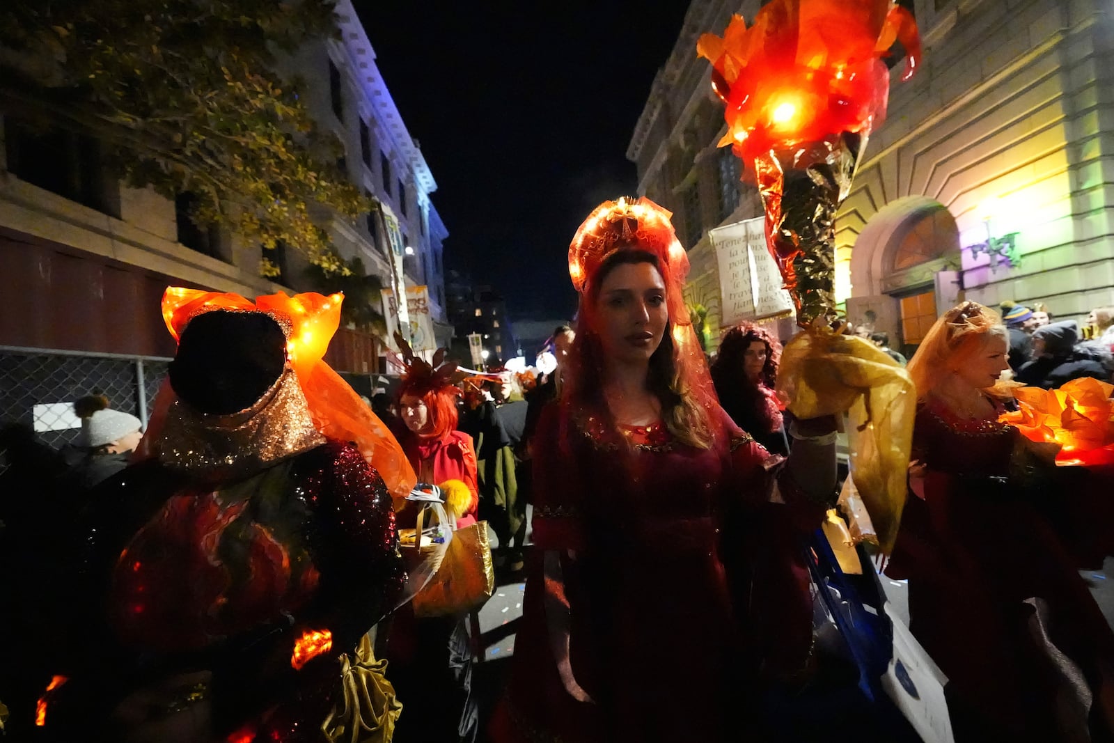 A woman holds a torch during the annual Krewe de Jeanne d'Arc parade, kicking off the Mardi Gras season, in New Orleans, Monday, Jan. 6, 2025. (AP Photo/Gerald Herbert)