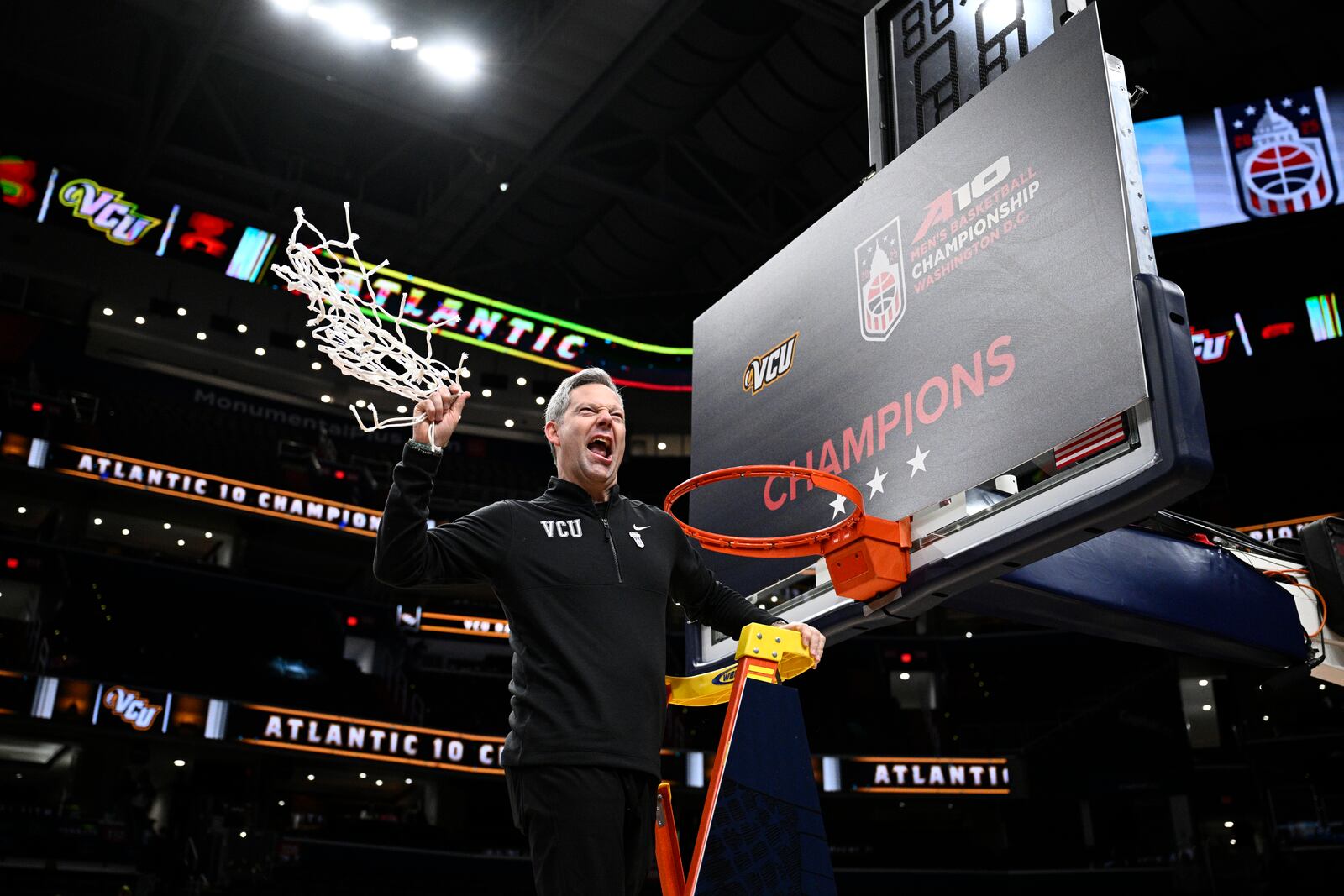 Virginia Commonwealth head coach Ryan Odom swings the net after cutting it down after winning an NCAA college basketball game in the championship of the Atlantic 10 tournament against George Mason, Sunday, March 16, 2025, in Washington. (AP Photo/Nick Wass)