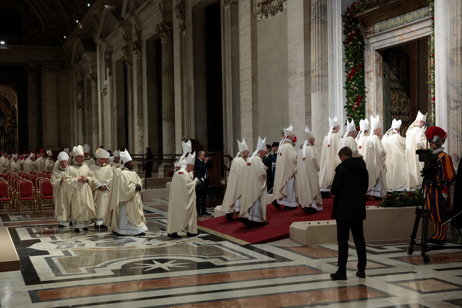 Members of the clergy walk after Pope Francis opened the Holy Door to mark the opening of the 2025 Catholic Holy Year, or Jubilee, in St. Peter's Basilica, at the Vatican, Tuesday Dec. 24, 2024. (Remo Casilli/Pool via AP)