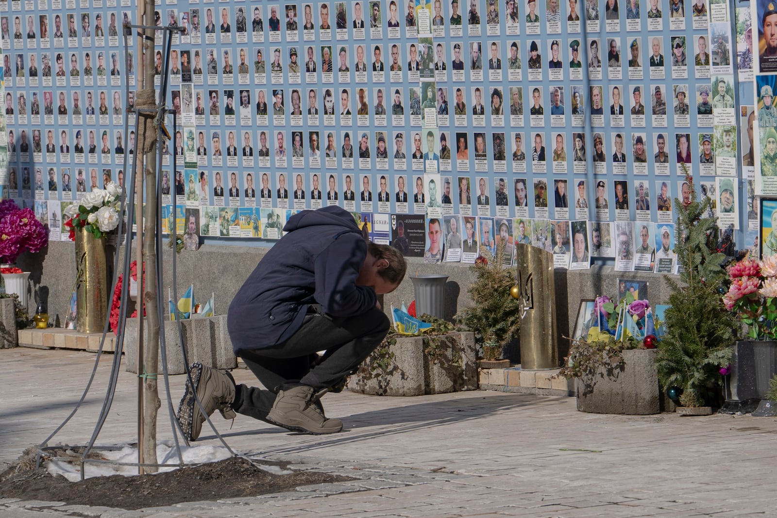 A man mourns at the Memorial Wall of Fallen Defenders of Ukraine in Russian-Ukrainian War in Kyiv, Ukraine, Monday, Feb. 24, 2025. (AP Photo/Andrew Kravchenko)