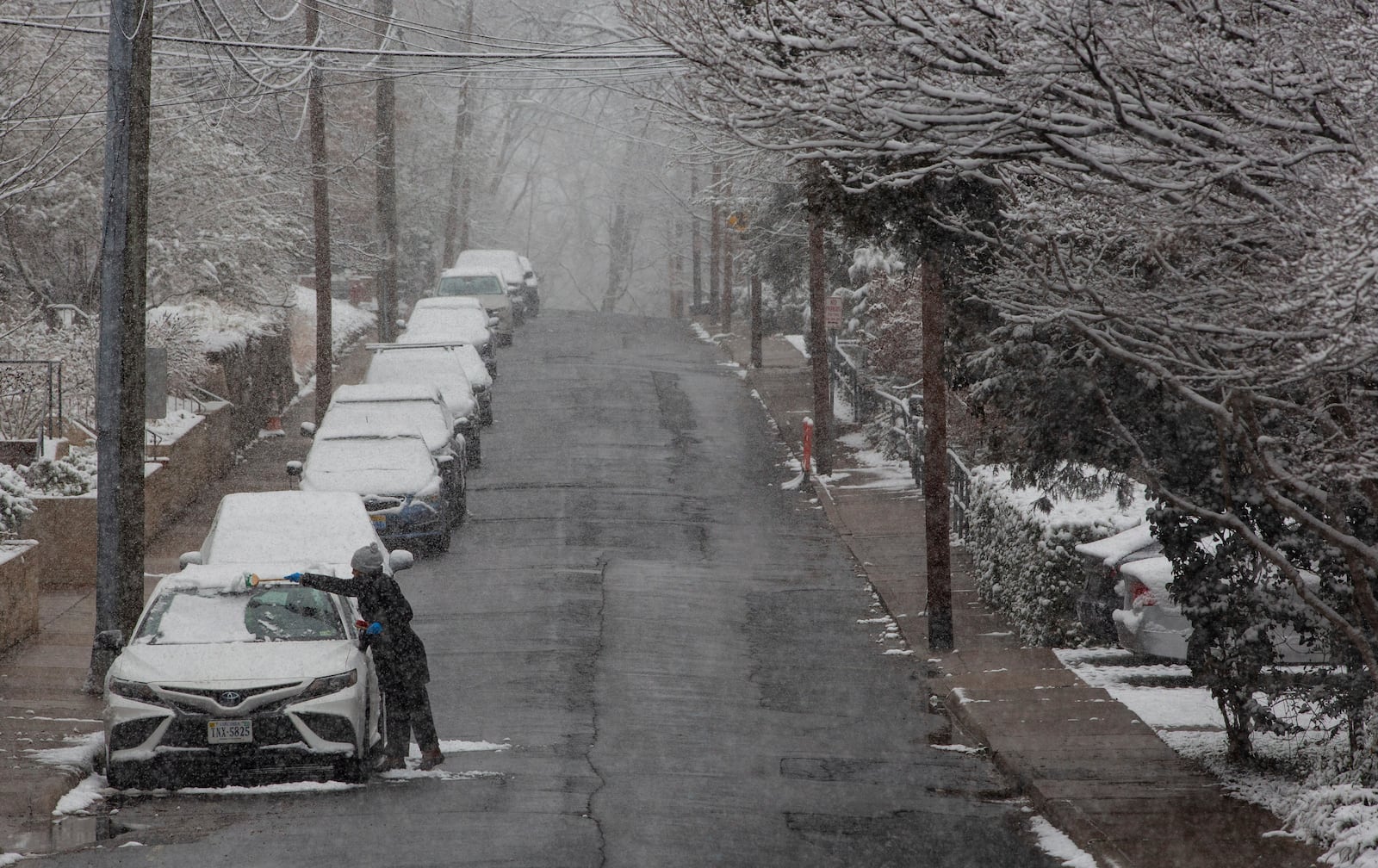 Alba Salinas clears snow off her car as a winter snowstorm hits Charlottesville, Va., Tuesday, Feb. 11, 2025. (Cal Cary/The Daily Progress via AP)