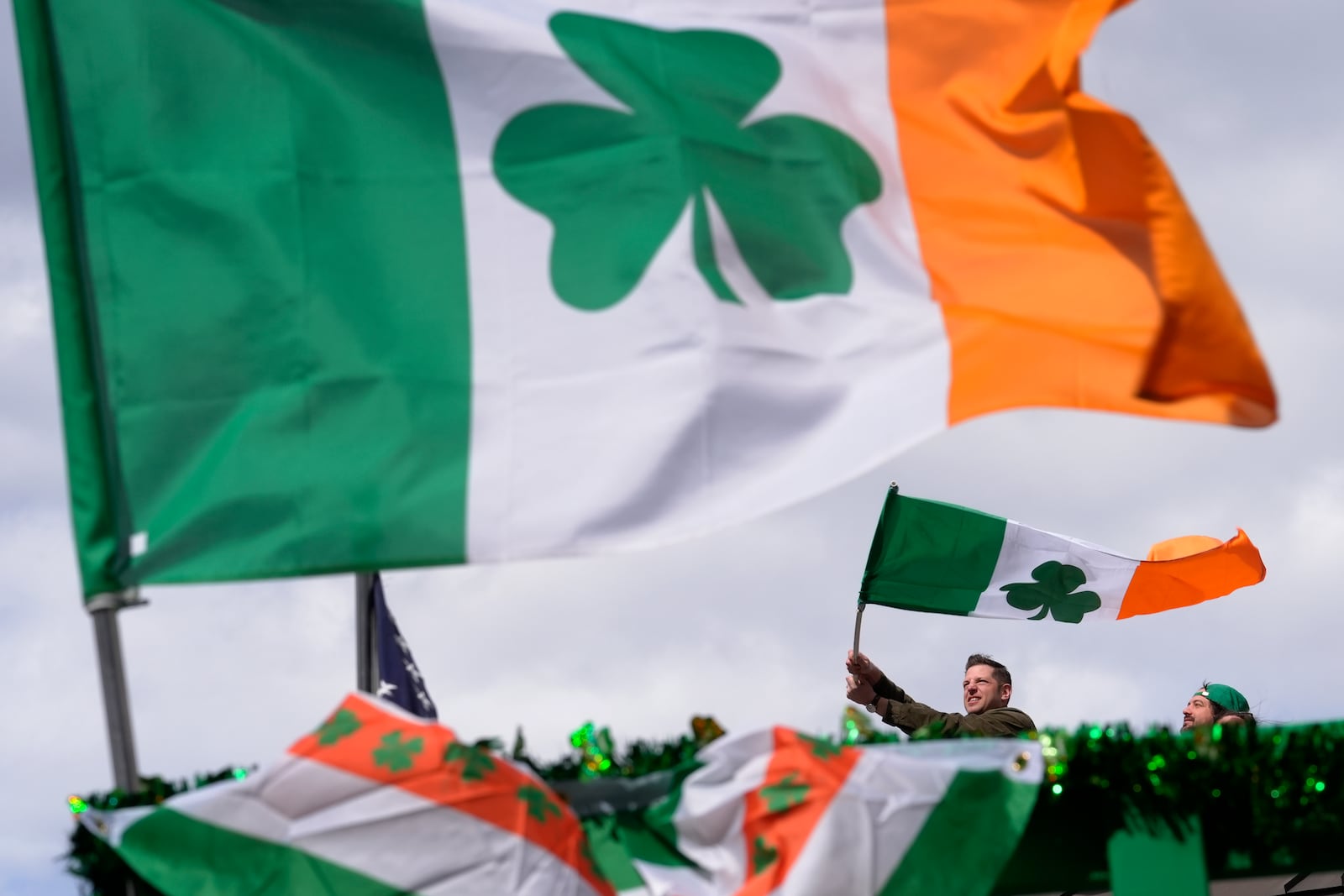 FILE - A person waves an Irish flag while watching the St. Patrick's Day parade, Sunday, March 17, 2024, in Boston's South Boston neighborhood. (AP Photo/Steven Senne, File)