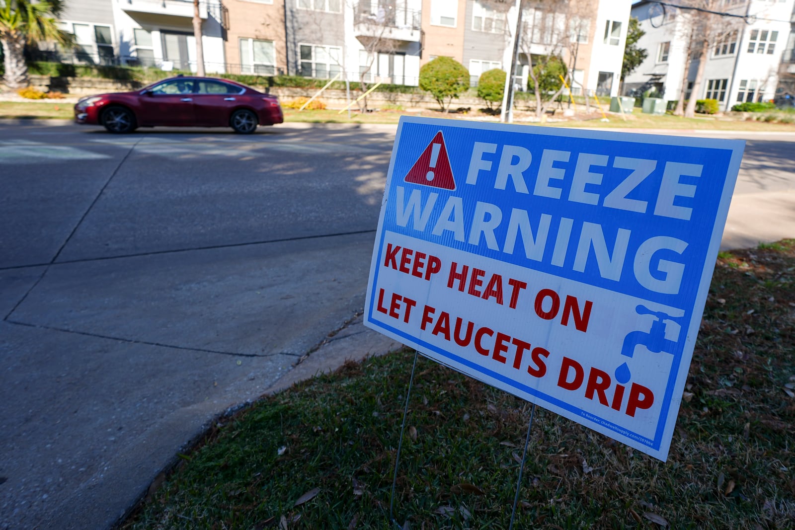 A freeze warning sign is stands outside of an apartment complex ahead of a winter storm expected to hit the North Texas region, Tuesday, Jan. 7, 2025, in Dallas. (AP Photo/Julio Cortez)