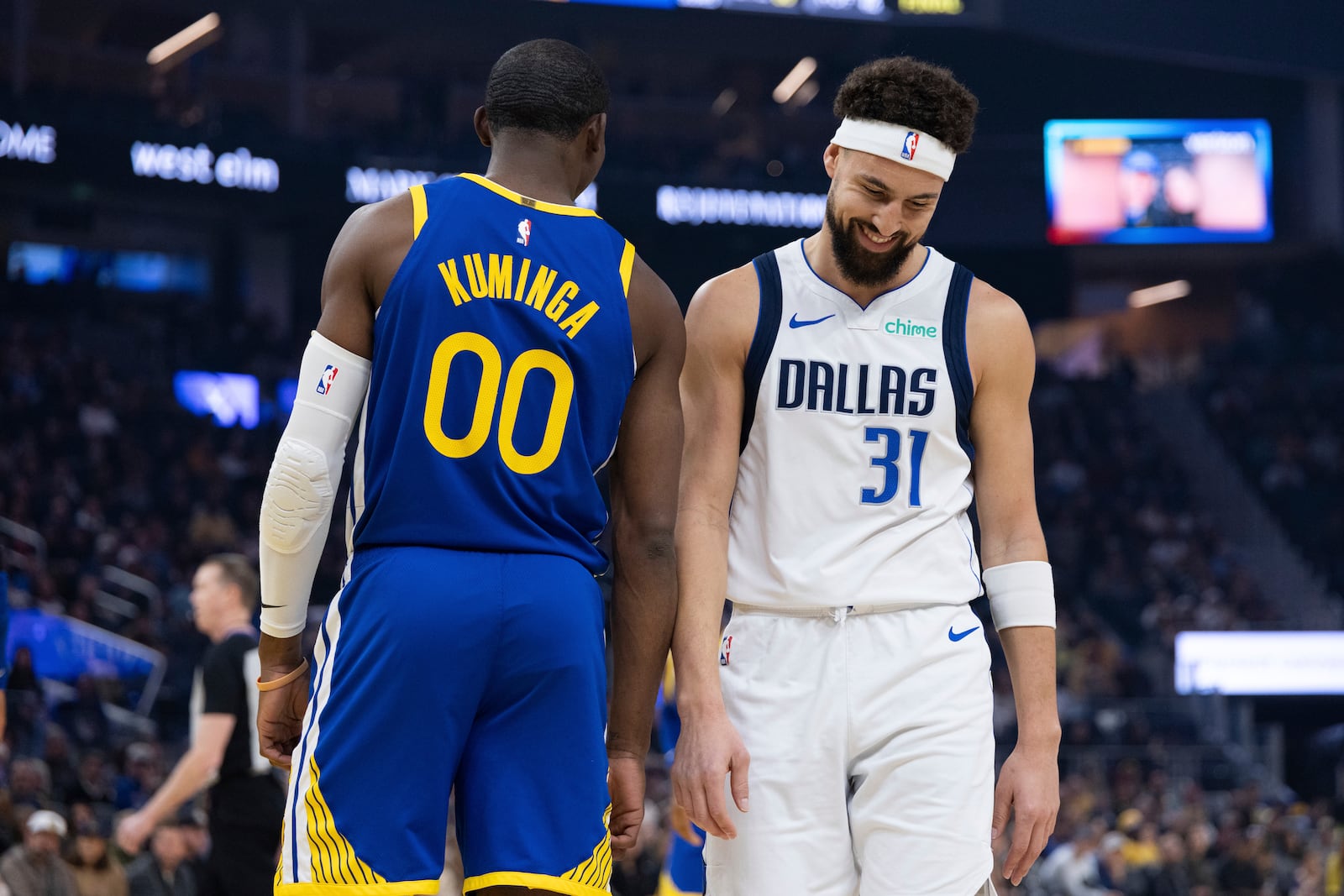 Golden State Warriors forward Jonathan Kuminga (00) stands as Dallas Mavericks guard Klay Thompson walks past during the first half of an NBA basketball game Sunday, Dec. 15, 2024, in San Francisco. (AP Photo/Benjamin Fanjoy)