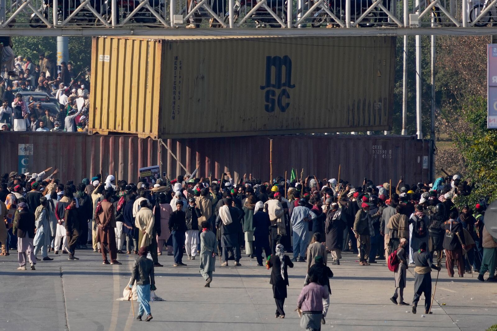 Supporters of imprisoned former premier Imran Khan's Pakistan Tehreek-e-Insaf party, remove shipping container to clear way for their rally demanding Khan's release, in Islamabad, Pakistan, Tuesday, Nov. 26, 2024. (AP Photo/Anjum Naveed)