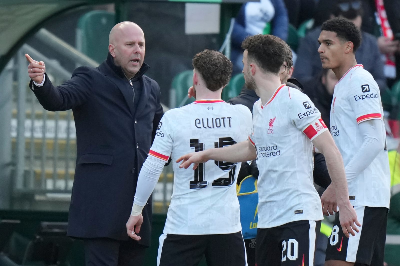 Liverpool's manager Arne Slot, left gestures as he speaks to his players Liverpool's Harvey Elliott, Liverpool's Diogo Jota during the English FA Cup fourth round soccer match between Plymouth Argyle and Liverpool at Home Park stadium in Plymouth, England, Sunday, Feb. 9, 2025. (AP Photo/Alastair Grant)