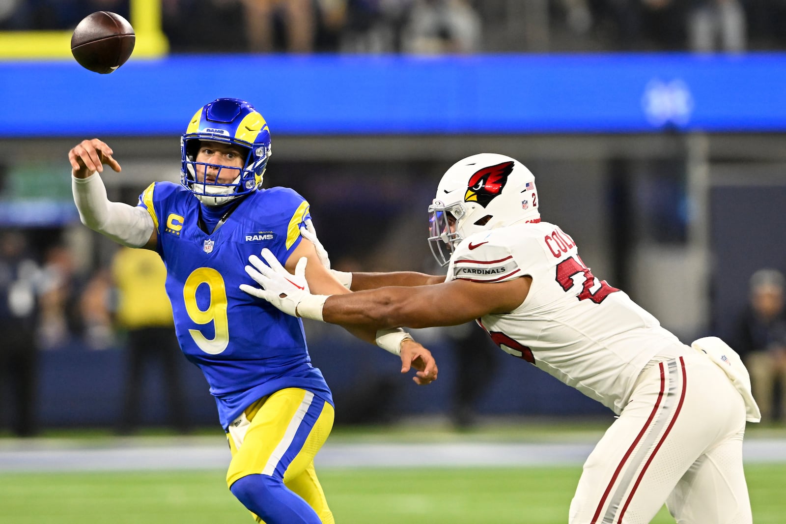 Los Angeles Rams quarterback Matthew Stafford (9) throws under pressure from Arizona Cardinals linebacker Zaven Collins (25) during the first half of an NFL football game Saturday, Dec. 28, 2024, in Inglewood, Calif. (AP Photo/Alex Gallardo)