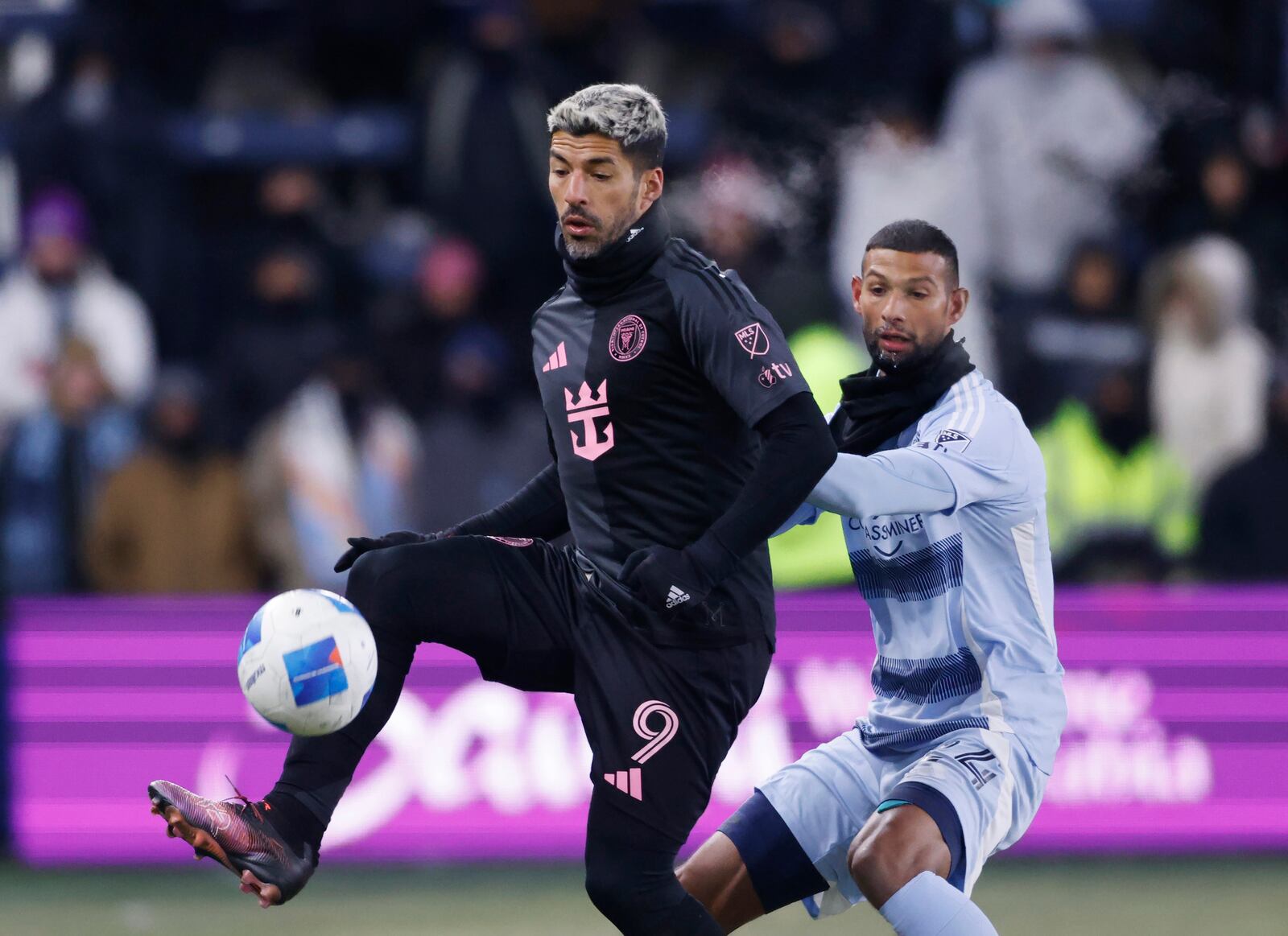 Inter Miami forward Luis Suárez (9) controls a pass as Sporting Kansas City defender Joaquín defends during the second half of a CONCACAF Champions Cup soccer match, Wednesday, Feb. 19, 2025, in Kansas City, Kan. (AP Photo/Colin E. Braley)