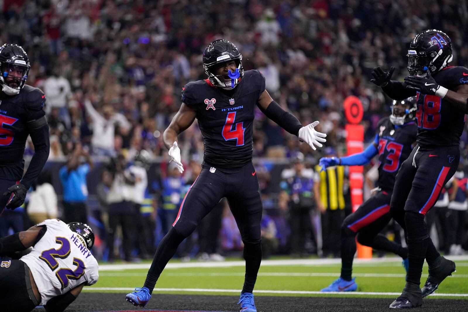 Houston Texans cornerback Kamari Lassiter (4) celebrates after tackling Baltimore Ravens running back Derrick Henry (22) for a safety during the first half of an NFL football game, Wednesday, Dec. 25, 2024, in Houston. (AP Photo/Eric Christian Smith)