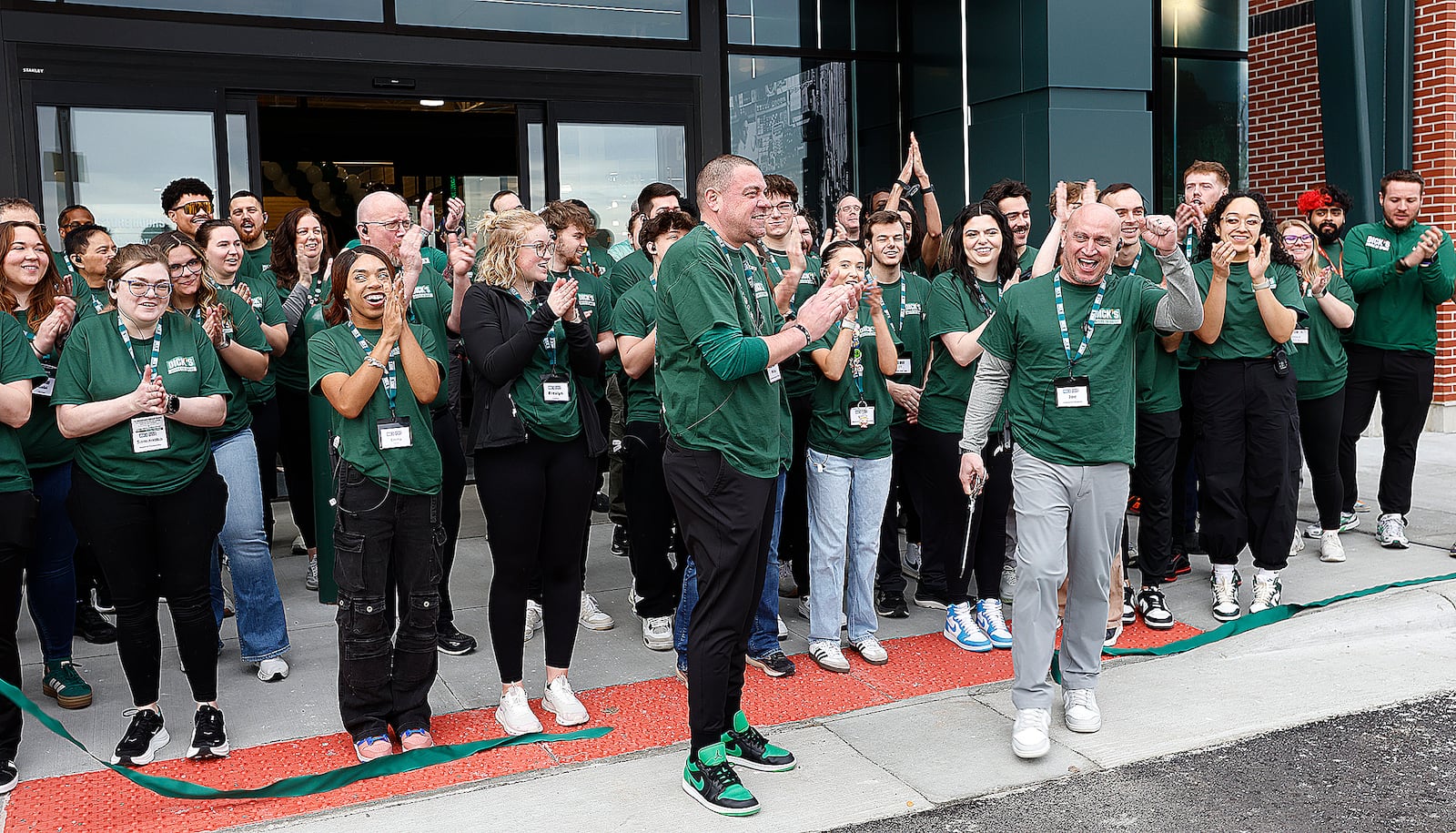 The staff at the new Dick's House of Sports at Fairfield Commons cheer Friday, March 7, 2025 after the ribbon cutting ceremony. MARSHALL GORBY\STAFF