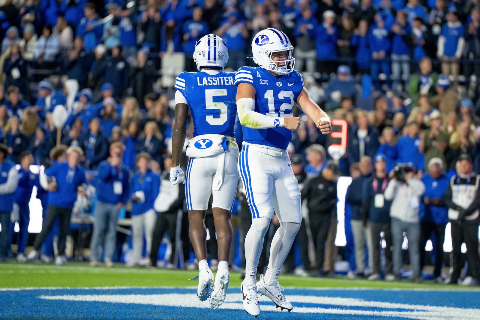 BYU wide receiver Darius Lassiter (5) and quarterback Jake Retzlaff (12) celebrate after Retzlaff ran for a touchdown in the first half of an NCAA college football game against Oklahoma State, Friday, Oct. 18, 2024, in Provo, Utah. (AP Photo/Spenser Heaps)