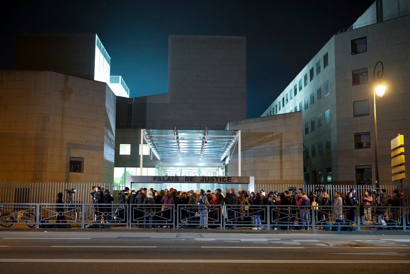 Media wait outside the courthouse of Avignon during the trial of four dozen men charged with aggravated rape and sexual assault on Gisèle Pelicot, in Avignon, southern France, Thursday, Dec. 19, 2024. (AP Photo/Lewis Joly)