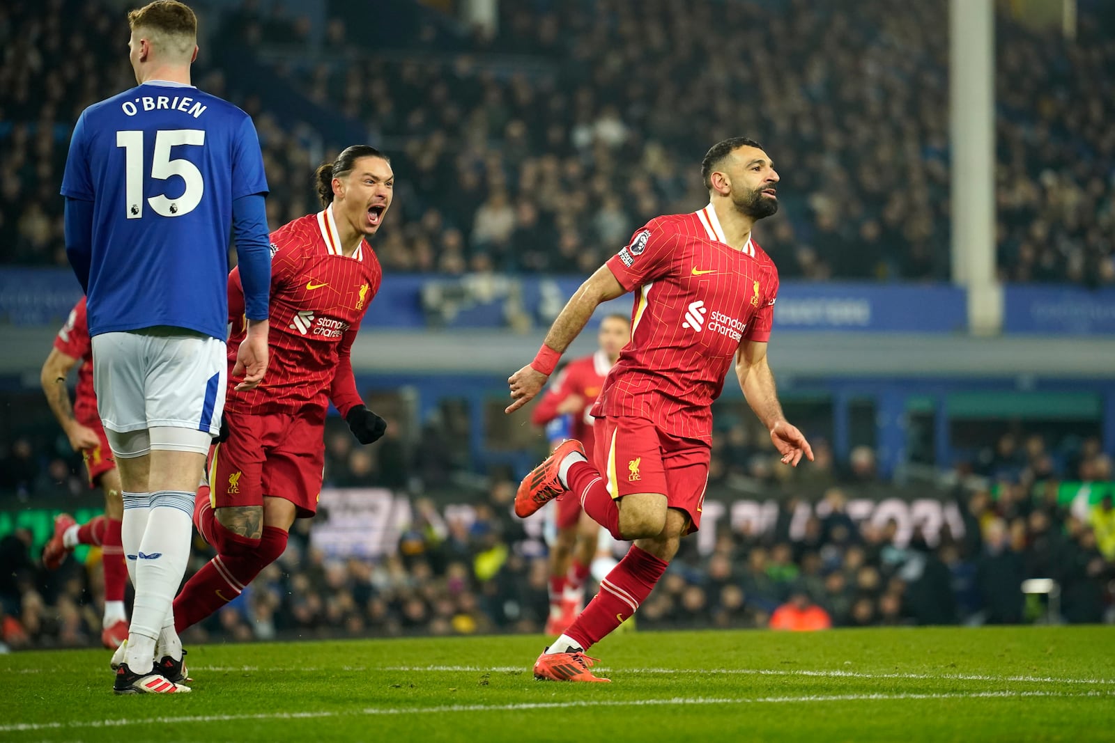 Liverpool's Mohamed Salah, right, celebrates after scoring his side's second goal during the English Premier League soccer match between Everton and Liverpool, Liverpool, England, Wednesday, Feb.12, 2025. (AP Photo/Dave Thompson)