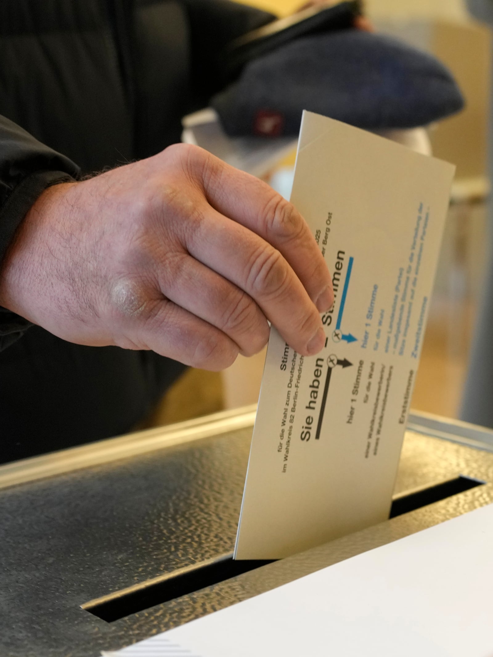 A resident casts a vote at a polling station in Berlin, Germany, Sunday, Feb. 23, 2025, during the German national election. (AP Photo/Markus Schreiber)