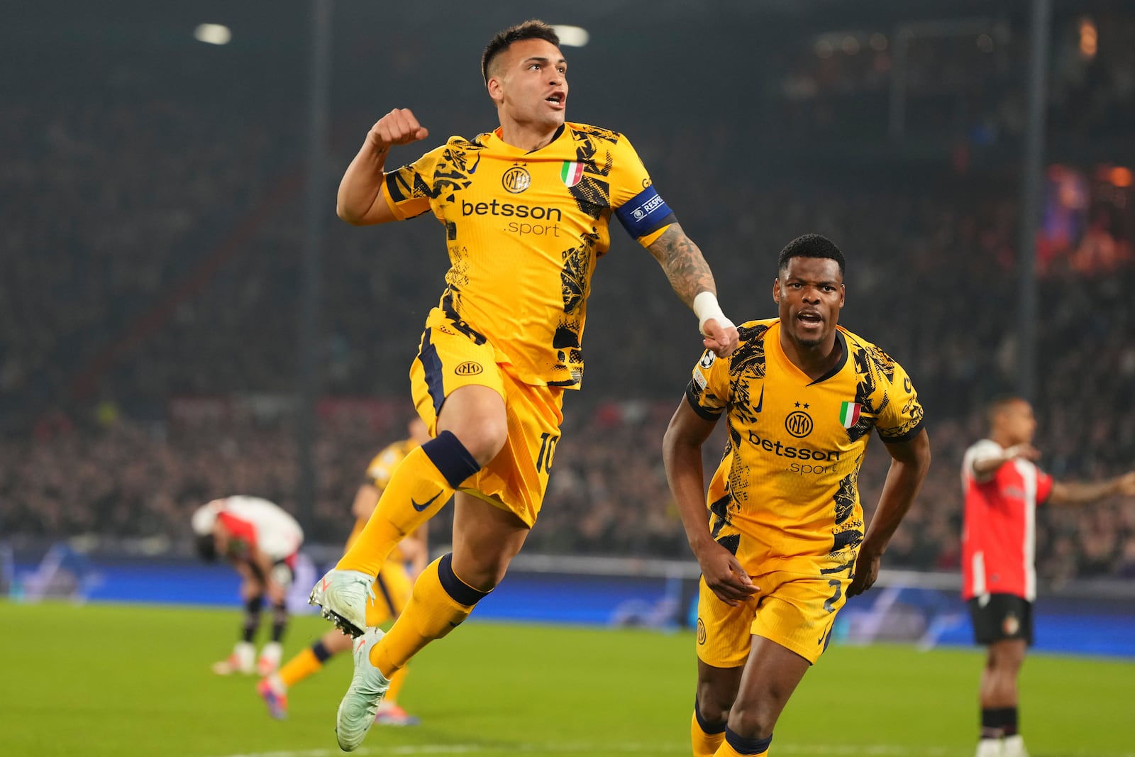 Inter Milan's Lautaro Martinez, left, celebrates after scoring during the Champions League round of 16 first leg soccer match between Feyenoord and Inter Milan in Rotterdam, Netherlands, Wednesday, March 5, 2025. (AP Photo/Peter Dejong)