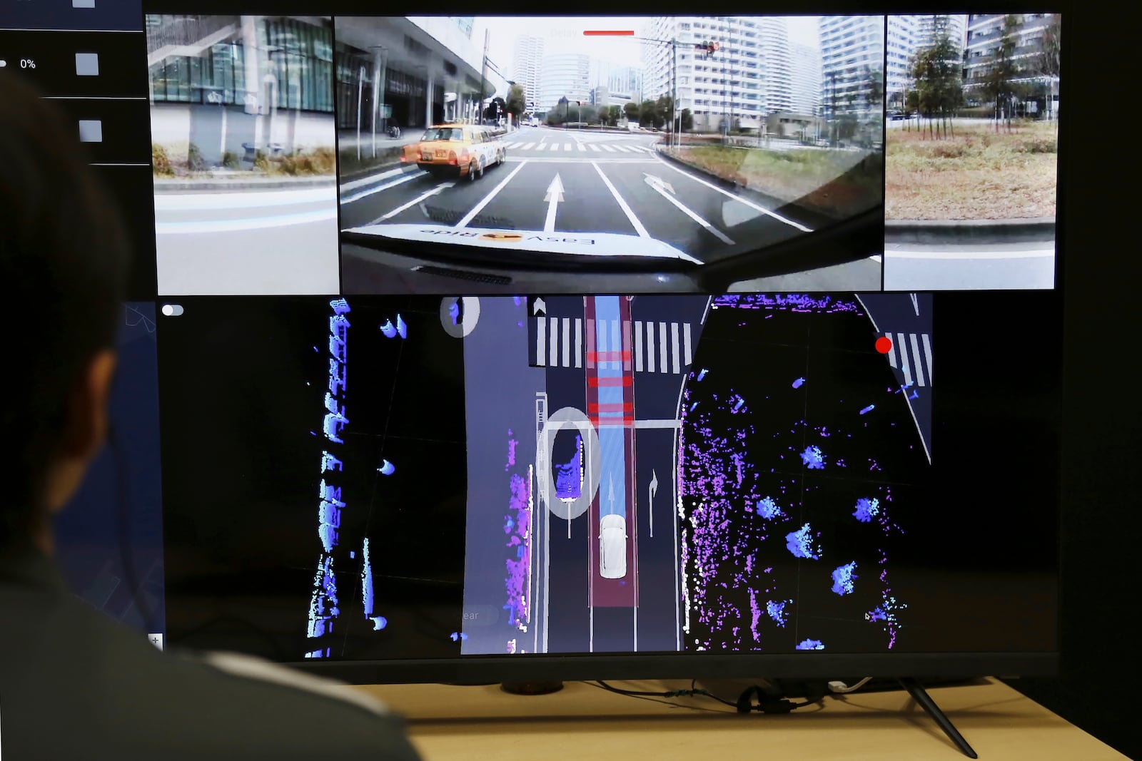 Nissan officials remotely monitor on screens the path and surroundings of the self-driving vehicle being tested on regular roads, so they can step in if problems happen, at Nissan headquarters in Yokohama, near Tokyo, on March 6, 2025. (AP Photo/Yuri Kageyama)