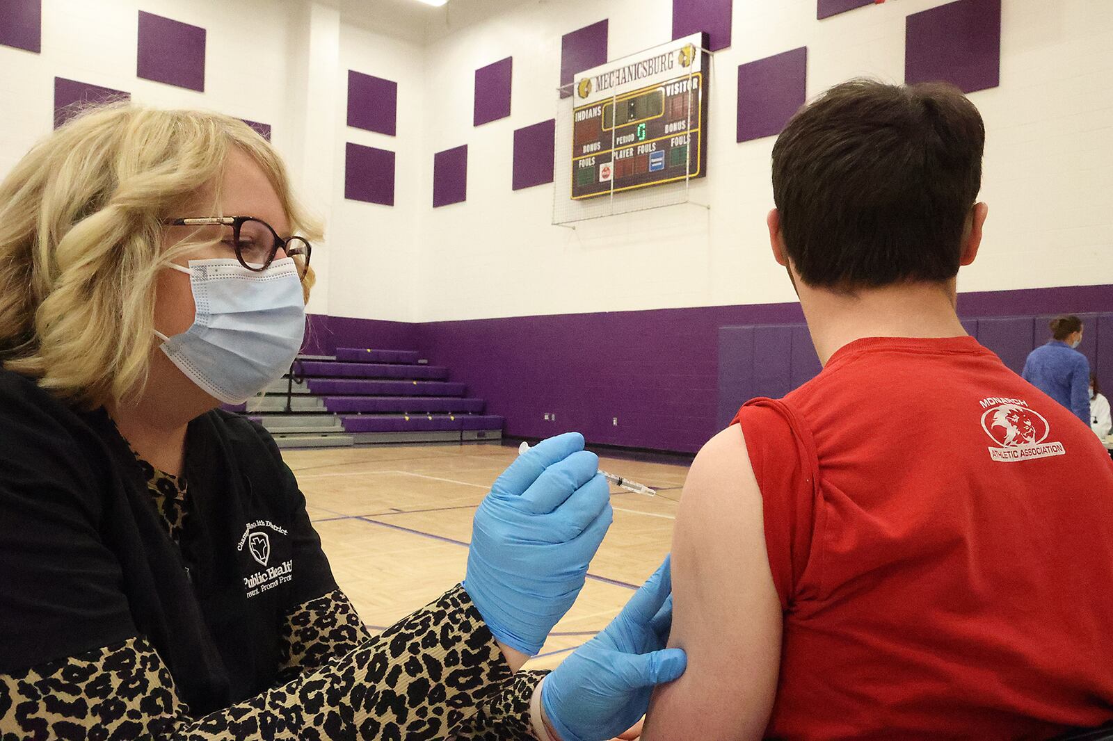 Student Alden Prohaska gets the COVID vaccine from Hope Stickley, a nurse from the Champaign County Health Department, Thursday during a COVID clinic in one of  Mechanicsburg High School's gymnasiums. BILL LACKEY/STAFF