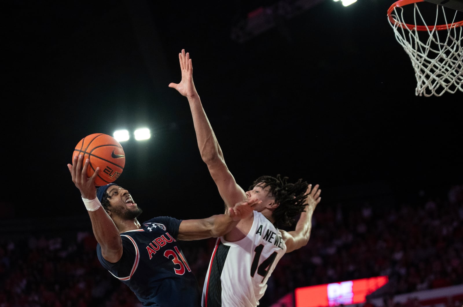 Auburn forward Chaney Johnson (31) shoots over Georgia forward Asa Newell (14) during the second half of an NCAA college basketball game, Saturday, Jan. 18, 2025, in Athens, Ga. (AP Photo/Kathryn Skeean)