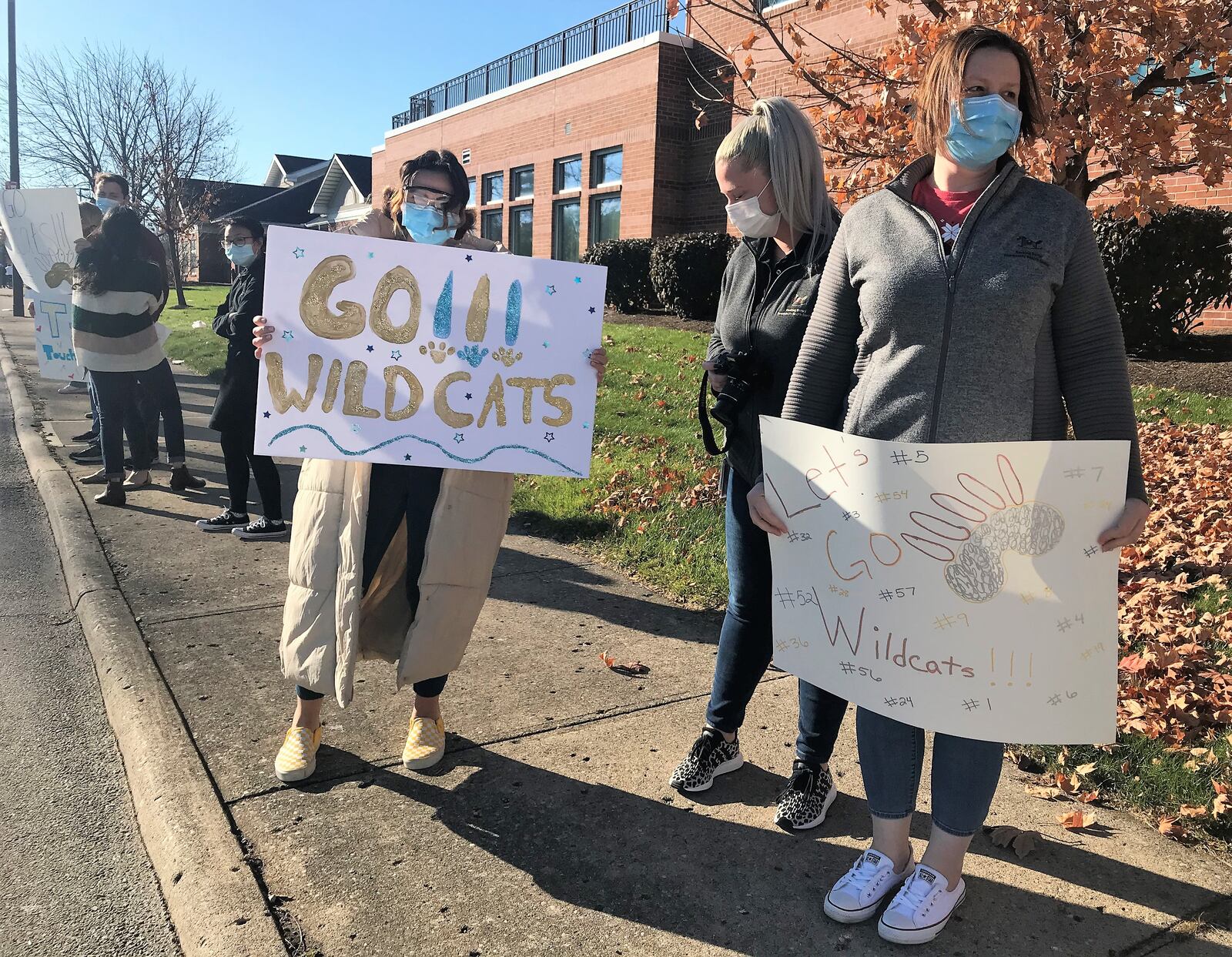 People gather outside of Rocking Horse Community Health Center Friday morning to show support to Springfield Highschool Football players heading to the state championship game. HASAN KARIM/STAFF