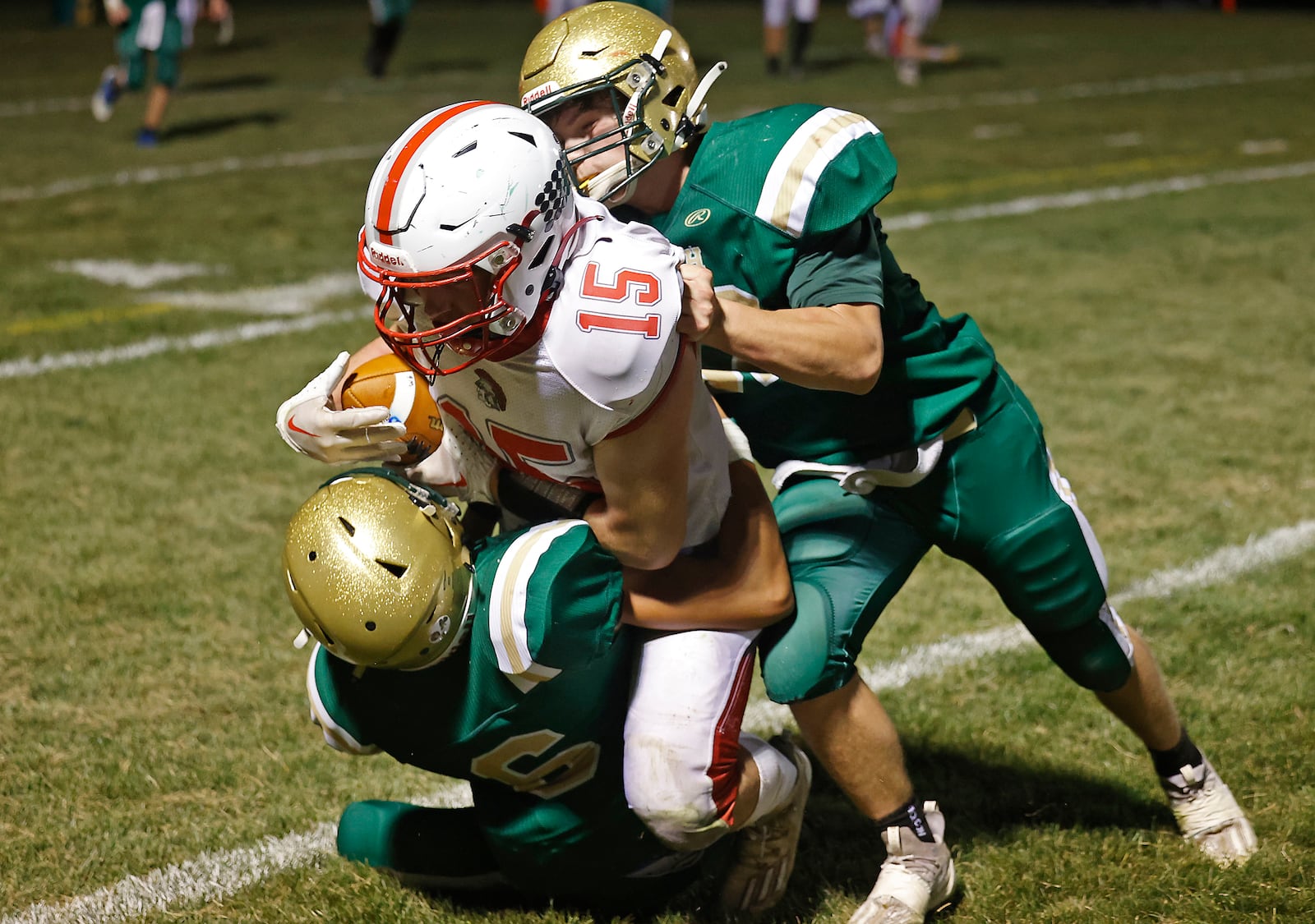 Southeastern's Hayden Davis is tackled by Catholic Central's Connor Cordell and Adam Thomas after catching a pass. BILL LACKEY/STAFF