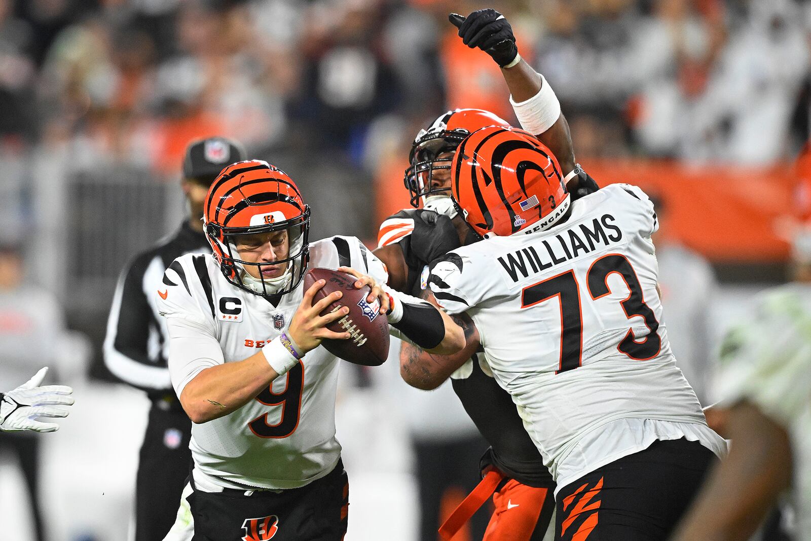 Cincinnati Bengals quarterback Joe Burrow (9) is rushed by Cleveland Browns defensive end Myles Garrett, center, with Bengals offensive tackle Jonah Williams (73) defending during the second half of an NFL football game in Cleveland, Monday, Oct. 31, 2022. (AP Photo/David Richard)