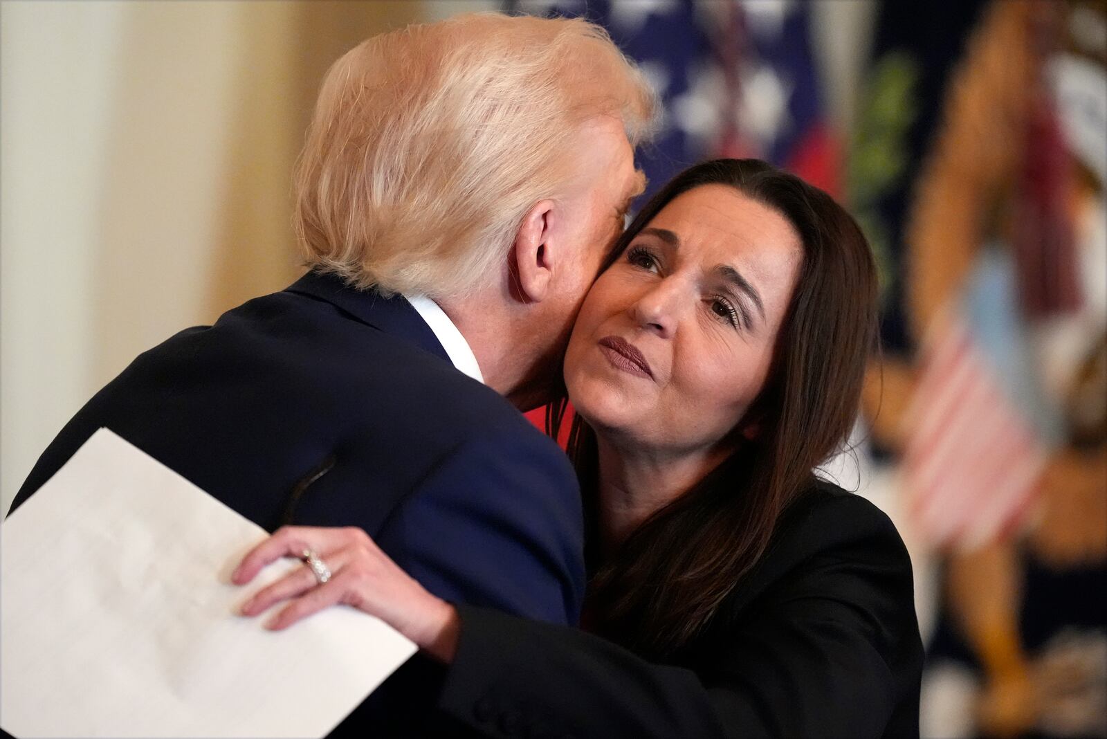 President Donald Trump hugs Allyson Phillips, mother of Laken Riley, before he signs the Laken Riley Act in the East Room of the White House, Wednesday, Jan. 29, 2025, in Washington. (AP Photo/Alex Brandon)