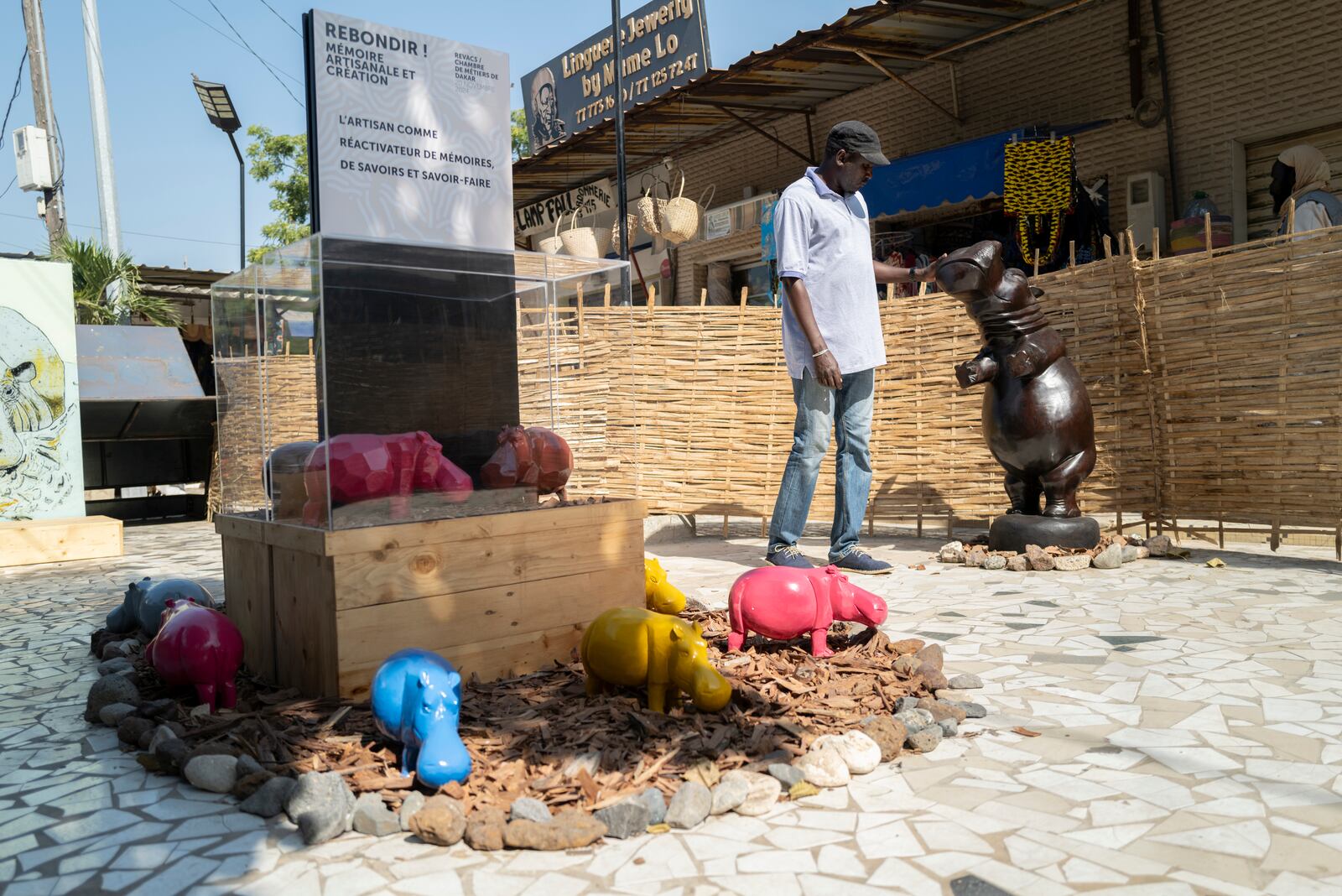 Ndiouga, president of the Soumbedioune craftsmen's association, visits the "rebondir" exhibition in Soubedioune as part of the Dakar 2024 Biennale Off in Dakar, Senegal, Thursday, Nov. 28, 2024. (AP Photo/Sylvain Cherkaoui)