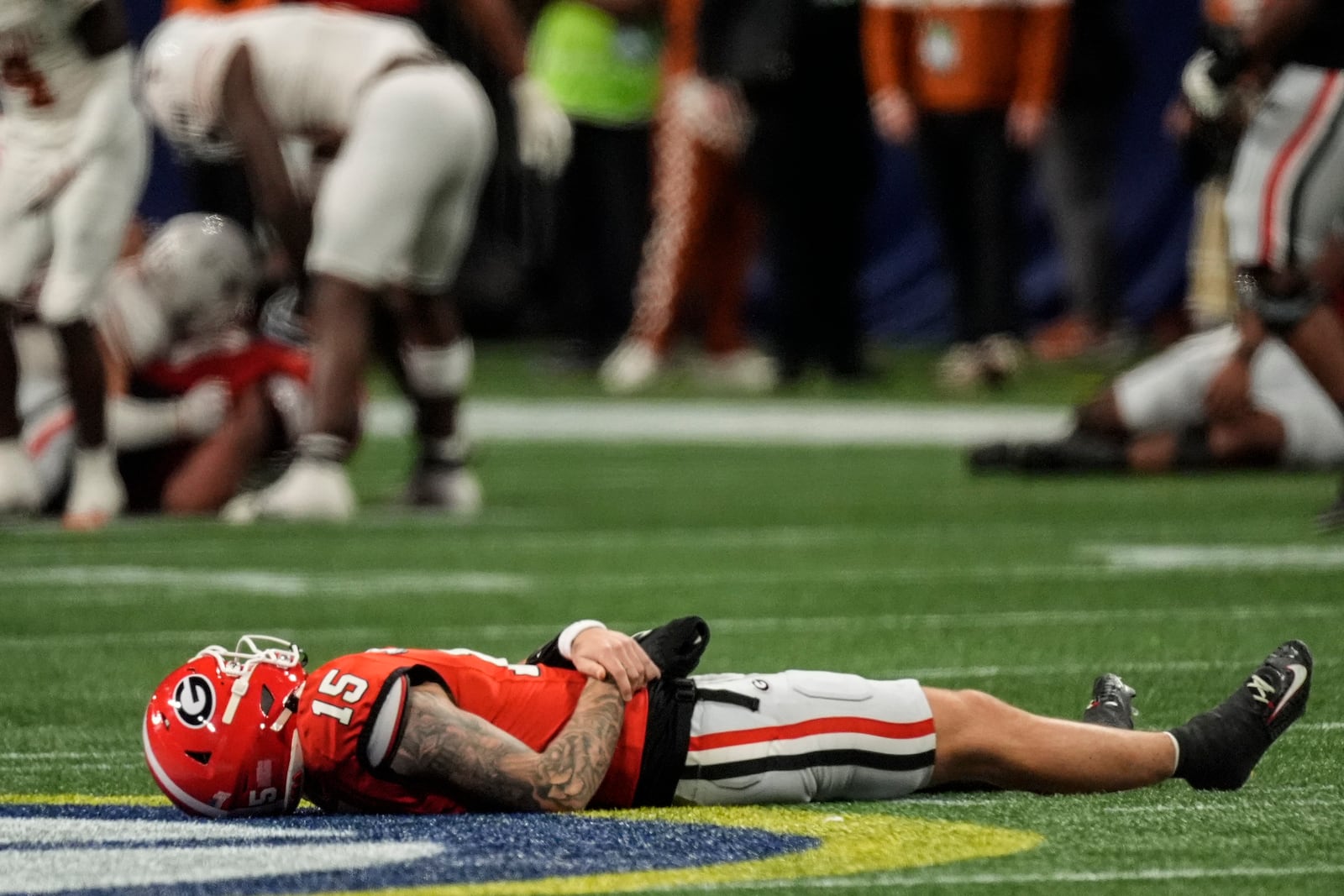 Georgia quarterback Carson Beck (15) lies on the turf injured against Texas during the first half of the Southeastern Conference championship NCAA college football game, Saturday, Dec. 7, 2024, in Atlanta. (AP Photo/John Bazemore)