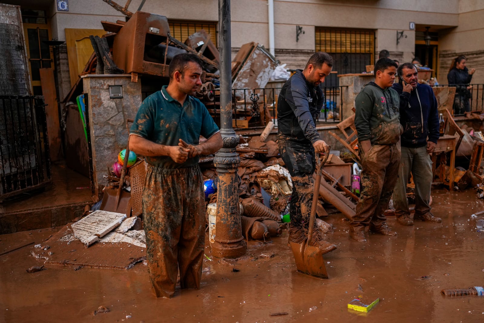 People clean their houses affected by floods in Utiel, Spain, Wednesday, Oct. 30, 2024. (AP Photo/Manu Fernandez)