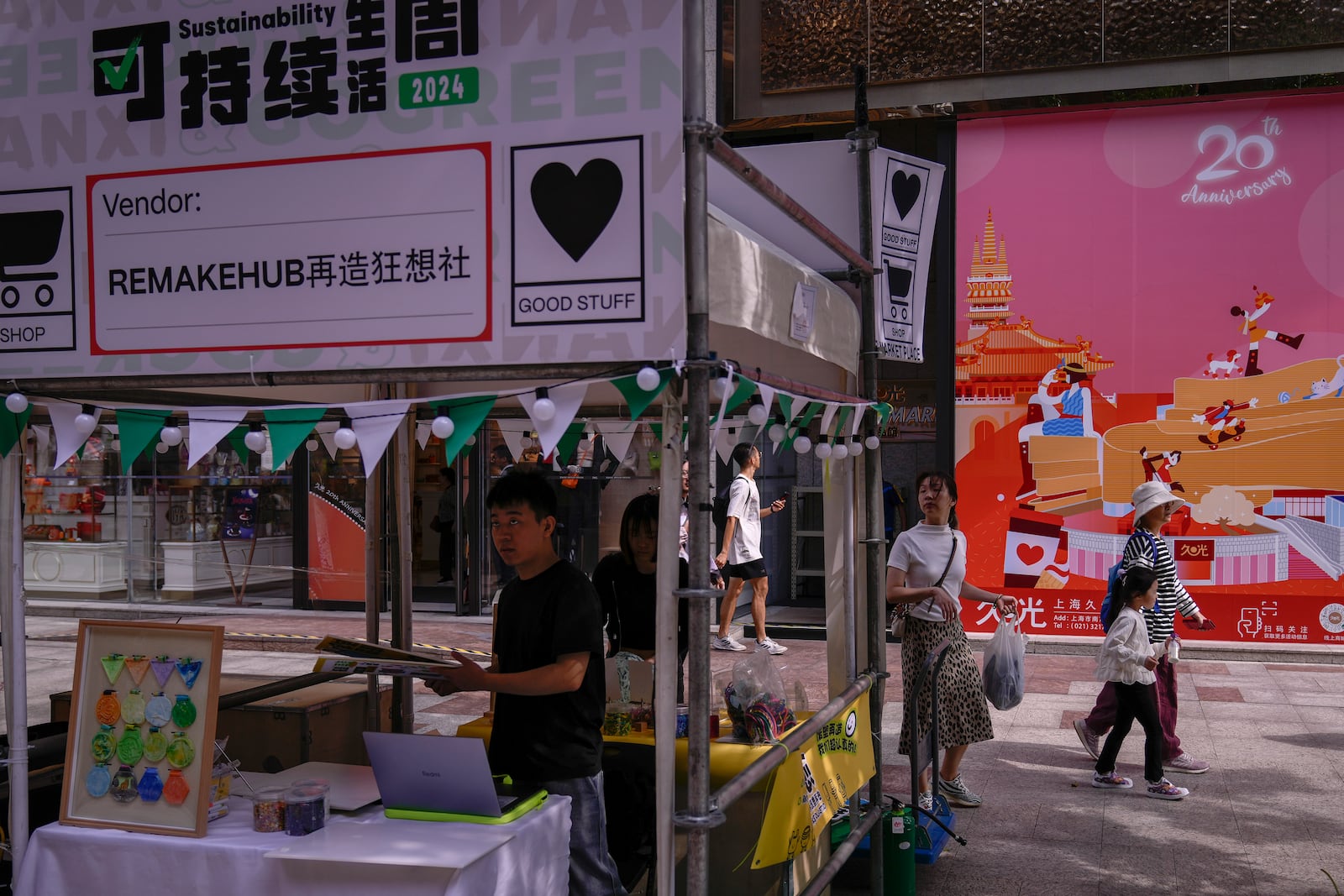 People walk by vendors set up their stores at a popular shopping district in Shanghai, China, Saturday, Oct. 12, 2024. (AP Photo/Andy Wong)