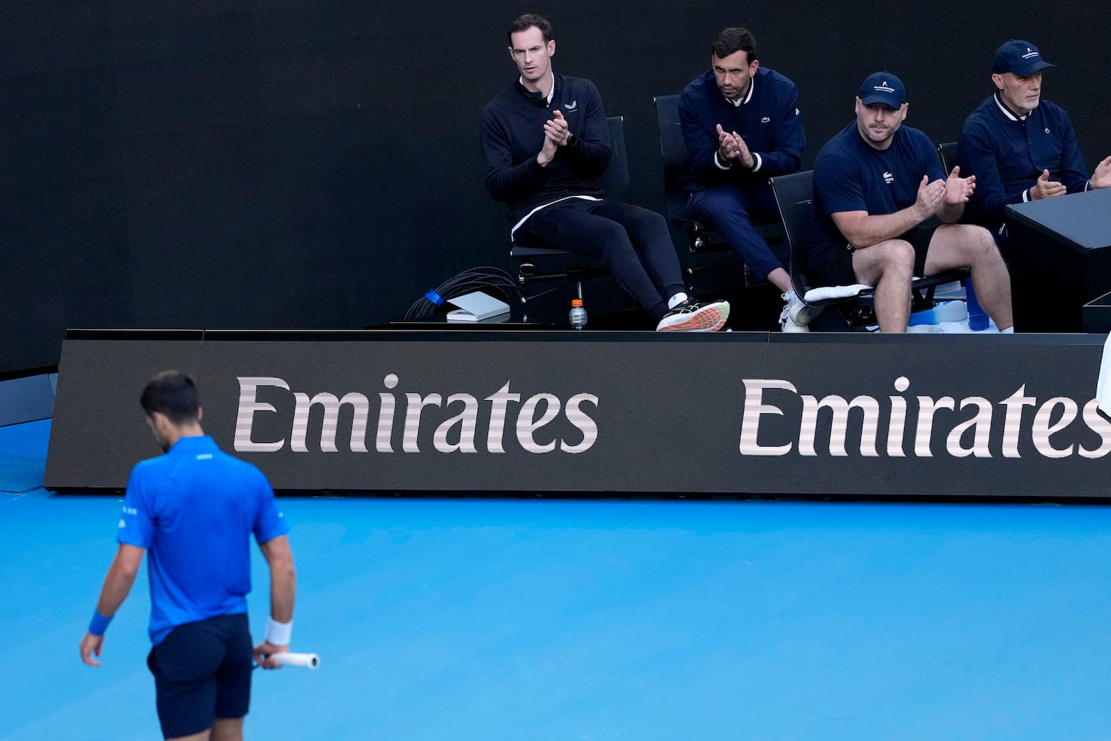 Andy Murray, top left, coach of Novak Djokovic of Serbia watches his first round match against Nishesh Basavareddy of the U.S. at the Australian Open tennis championship in Melbourne, Australia, Monday, Jan. 13, 2025. (AP Photo/Asanka Brendon Ratnayake)