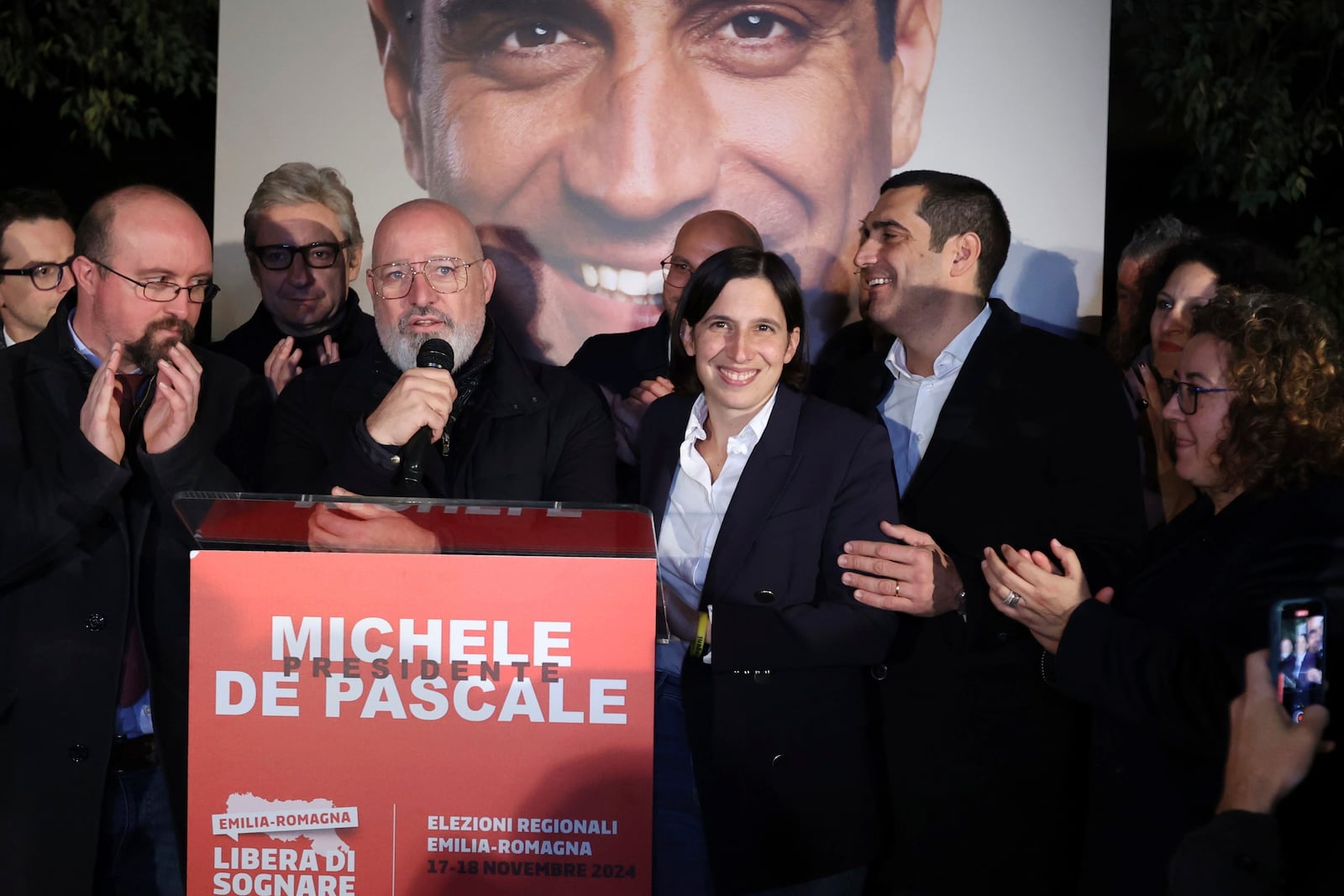 Democratic Party leader Elly Schlein, center, celebrates with candidate for the presidency of the region of Emilia Romagna Michele de Pascale, center right, following regional elections, in Bologna, Italy, Monday, Nov. 18, 2024. (Guido Calamosca/LaPresse via AP)