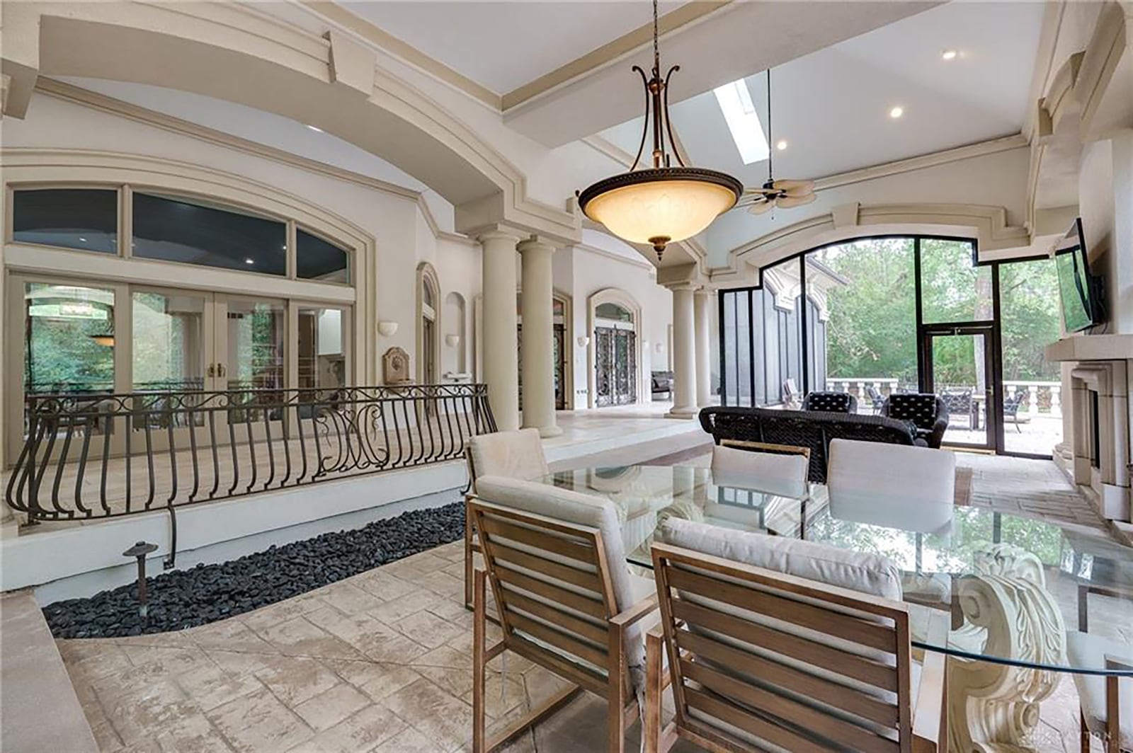 One of the homes many outdoor spaces includes this screened in porch with fireplace and tile flooring.