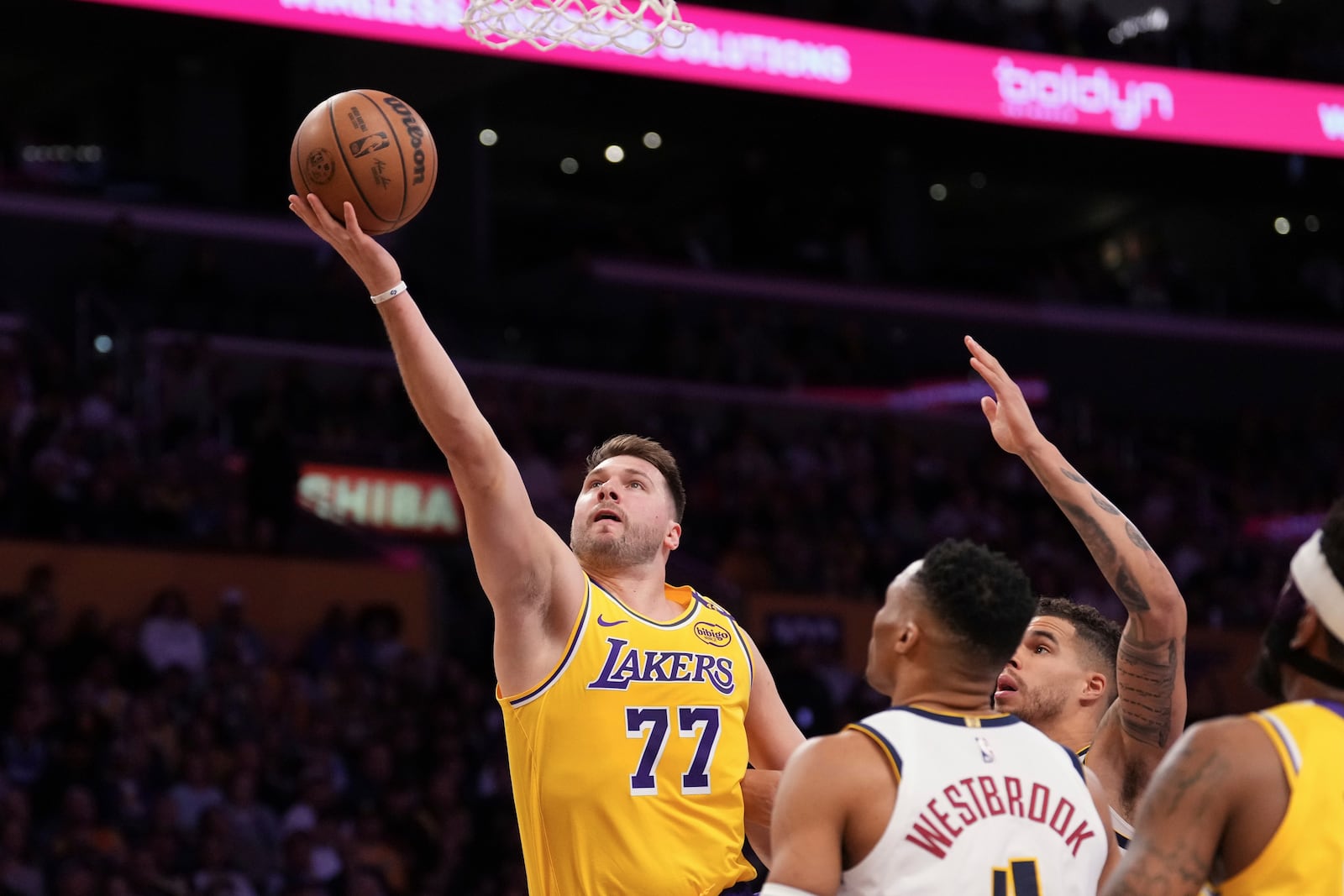 Los Angeles Lakers guard Luka Doncic, left, shoots as Denver Nuggets guard Russell Westbrook defends during the first half of an NBA basketball game Wednesday, March 19, 2025, in Los Angeles. (AP Photo/Mark J. Terrill)