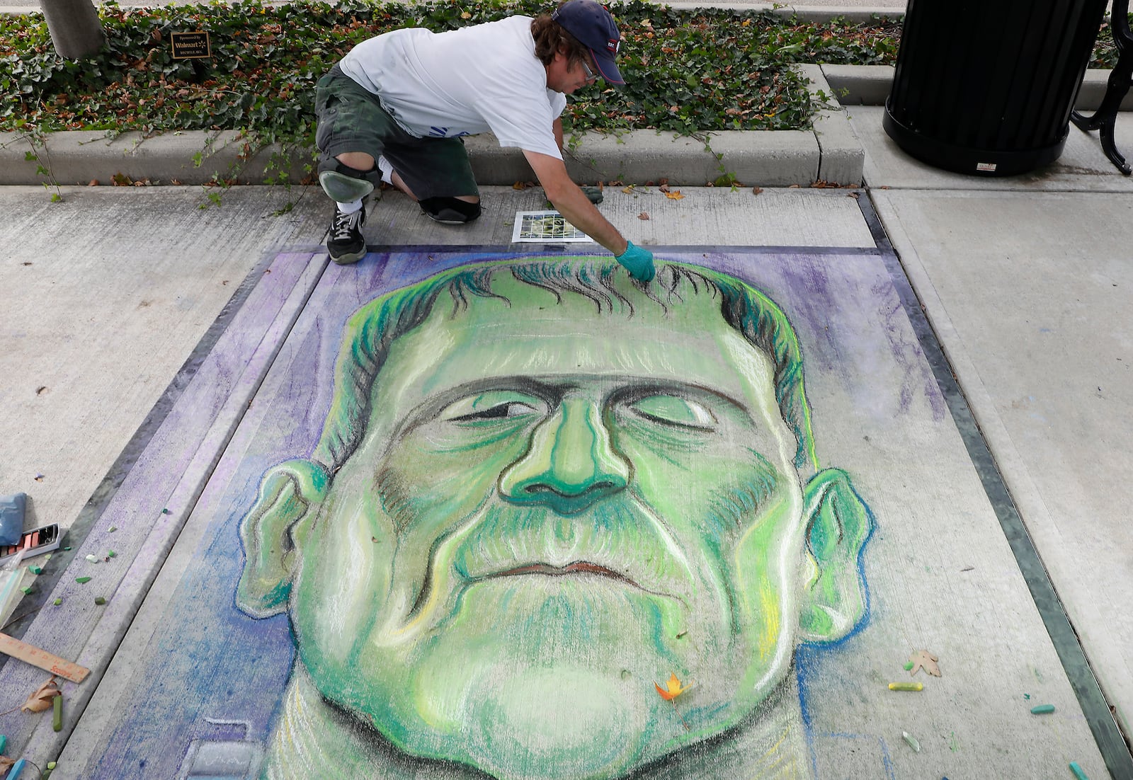 Paul Arnold work on his chalk picture Saturday during Chalktoberfest at Naional Road Commons Park. Bill Lackey/Staff