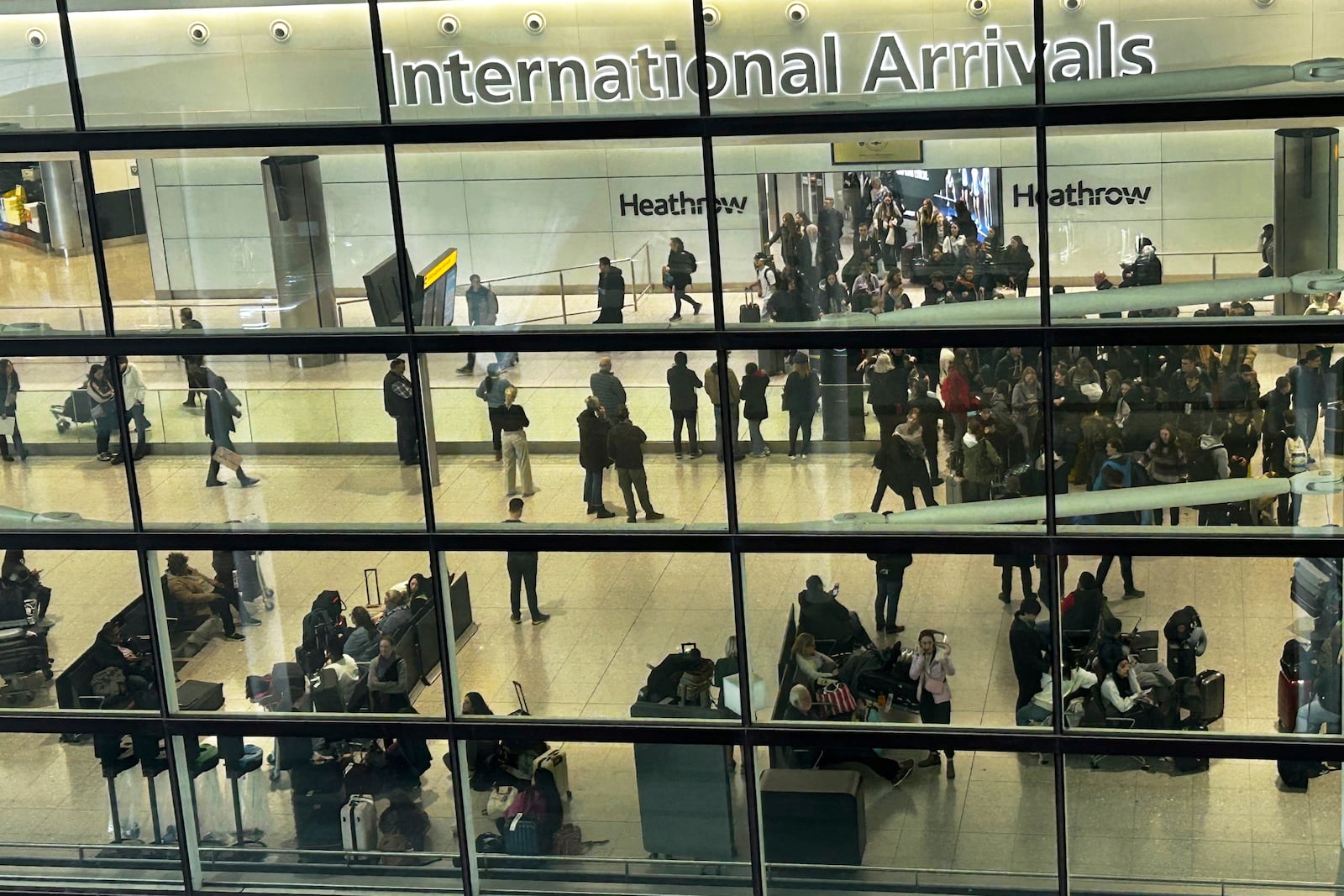 Travellers arrive at Terminal 2 as Heathrow Airport slowly resumes flights after a fire cut power to Europe's busiest airport in London, Saturday, March 22, 2025.(AP Photo/Kirsty Wigglesworth)