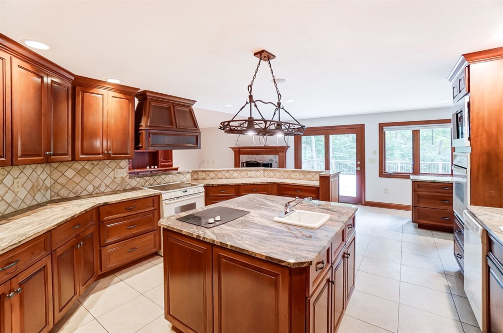 Light cherry cabinetry fills the kitchen and wraps around appliances that include a range, wall ovens, a dishwasher and refrigerator. 