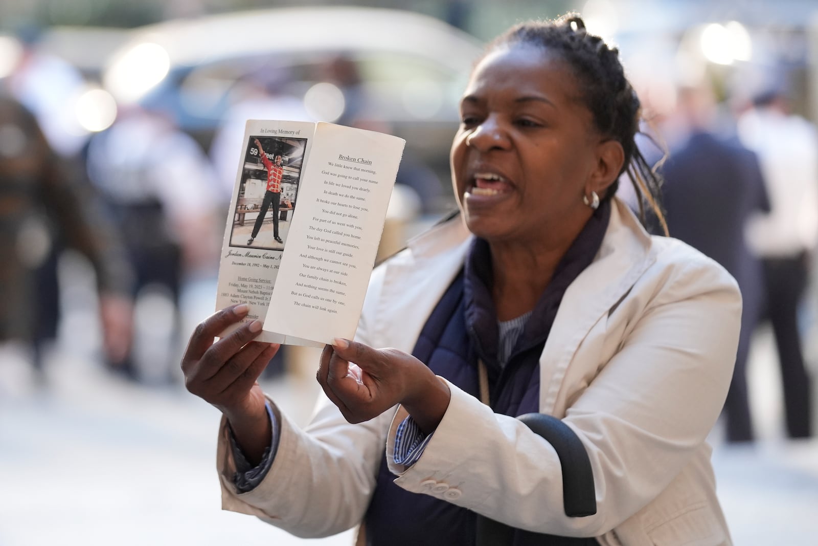 A woman yells and holds up a picture of Jordan Neely just before Daniel Penny arrives to Manhattan criminal court in New York, Monday, Oct. 21, 2024. (AP Photo/Seth Wenig)