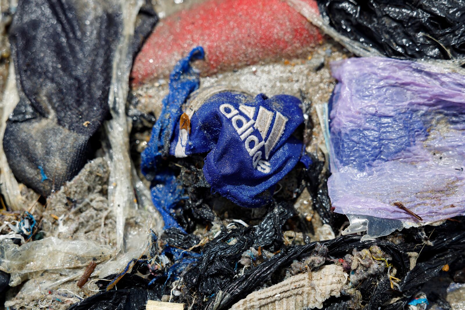 Second-hand clothes and waste pollute the beach shore at Jamestown in Accra, Ghana,Saturday, Oct. 19, 2024. (AP Photo/Misper Apawu)