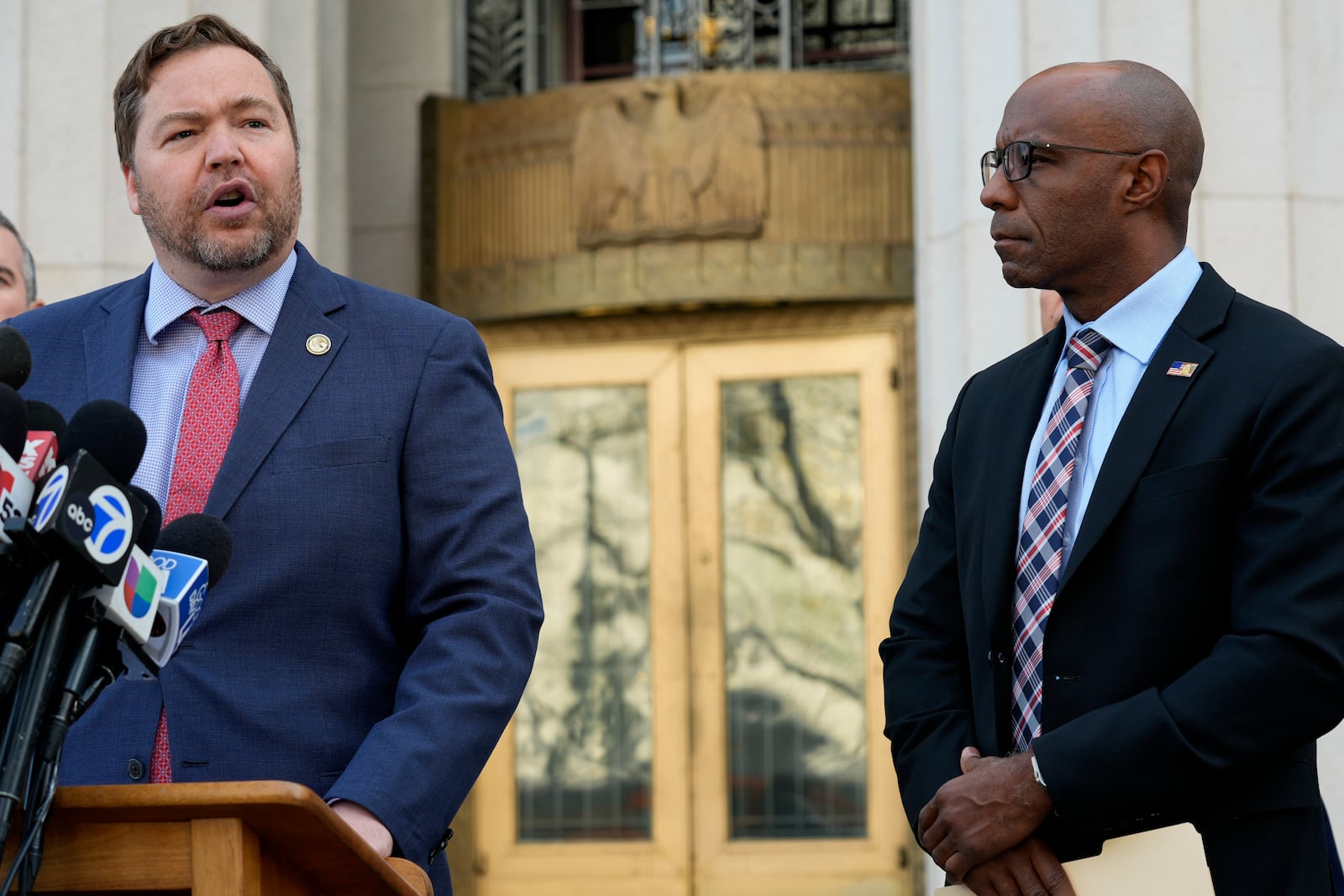 Acting U.S. Attorney Joseph T. McNally, left, joined by FBI Assistant Director Akil Davis, right, to discuss court filings related to the Palisades Fire investigation outside the U.S. Courthouse in downtown Los Angeles on Friday, Jan. 31, 2025. (AP Photo/Damian Dovarganes)