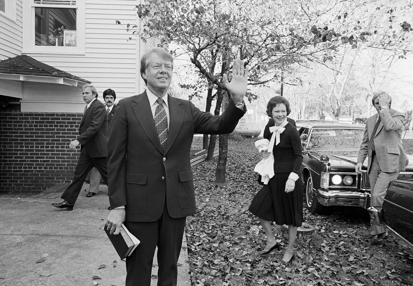 FILE - President-elect Jimmy Carter waves to the crowd as he and his wife Rosalynn arrive at the Plains Baptist Church to attend services in Plains, Ga., Nov. 22, 1976. (AP Photo, File)