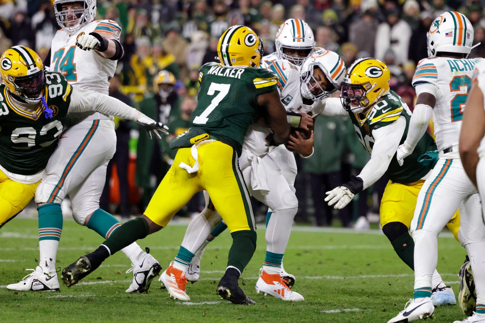 Miami Dolphins quarterback Tua Tagovailoa is sacked by Green Bay Packers linebacker Quay Walker (7) and defensive end Lukas Van Ness (90) during the second half of an NFL football game Thursday, Nov. 28, 2024, in Green Bay, Wis. (AP Photo/Matt Ludtke)