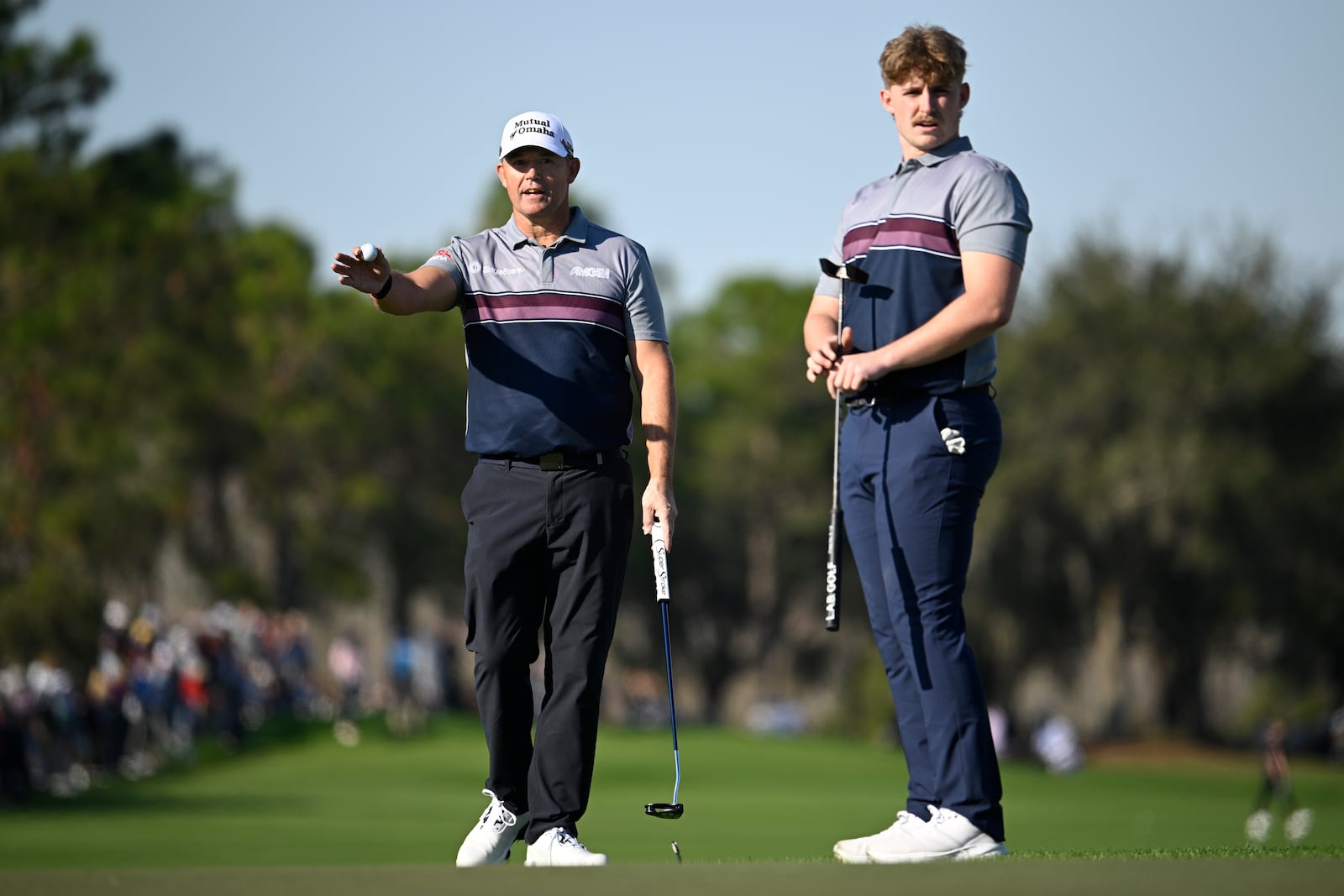 Padraig Harrington, left, and his son Paddy Harrington line up their putt on the 18th green hole during the first round of the PNC Championship golf tournament, Saturday, Dec. 21, 2024, in Orlando, Fla. (AP Photo/Phelan M. Ebenhack)