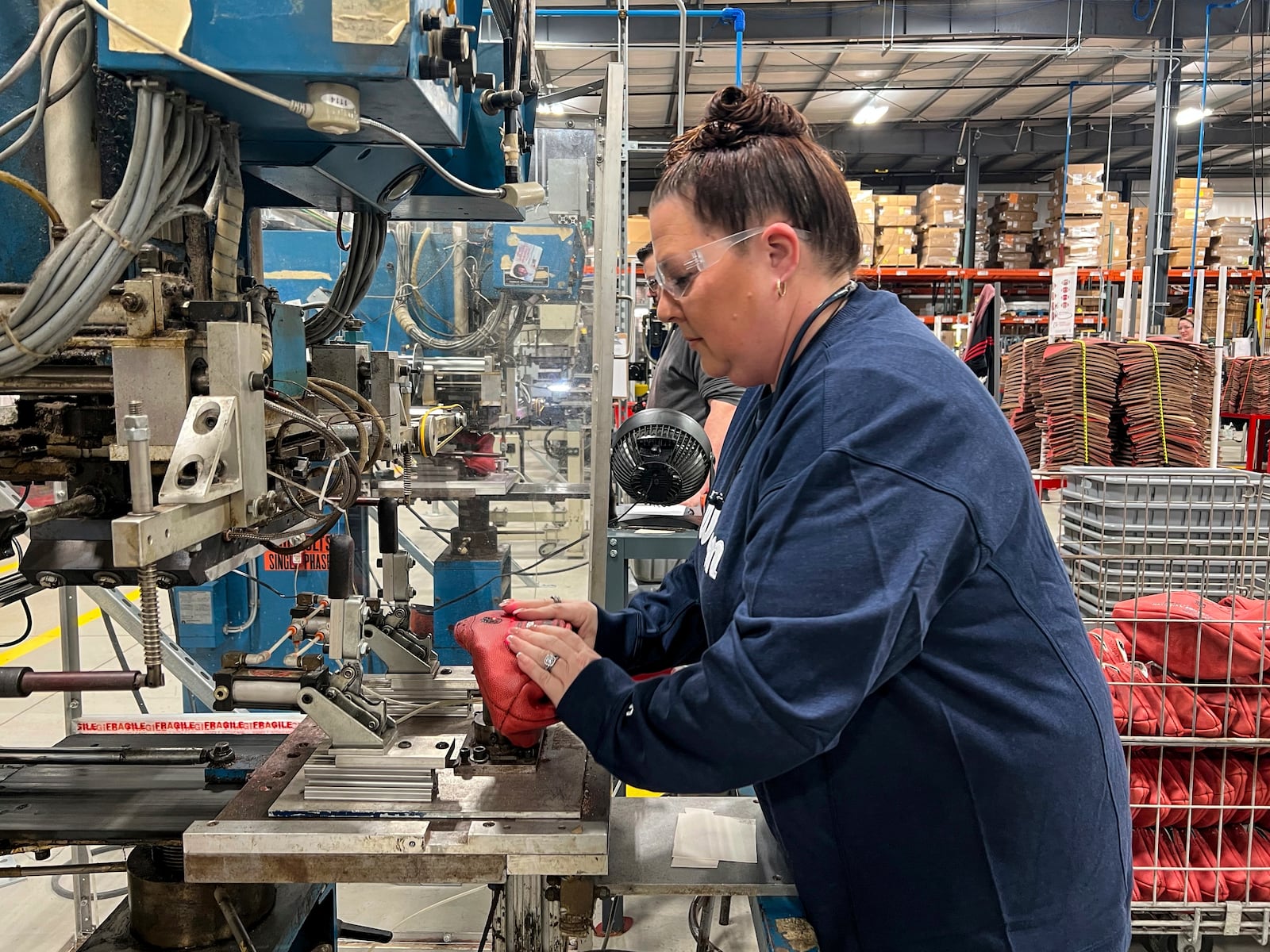 Nicole Snyder operates the machine inside the Wilson Sporting Goods football factory that prints "Philadelphia Eagles" and "Kansas City Chiefs" onto the official Super Bowl game balls Monday, January 27, 2025, in Ada, Ohio. (AP Photo/Patrick Aftoora-Orsagos)