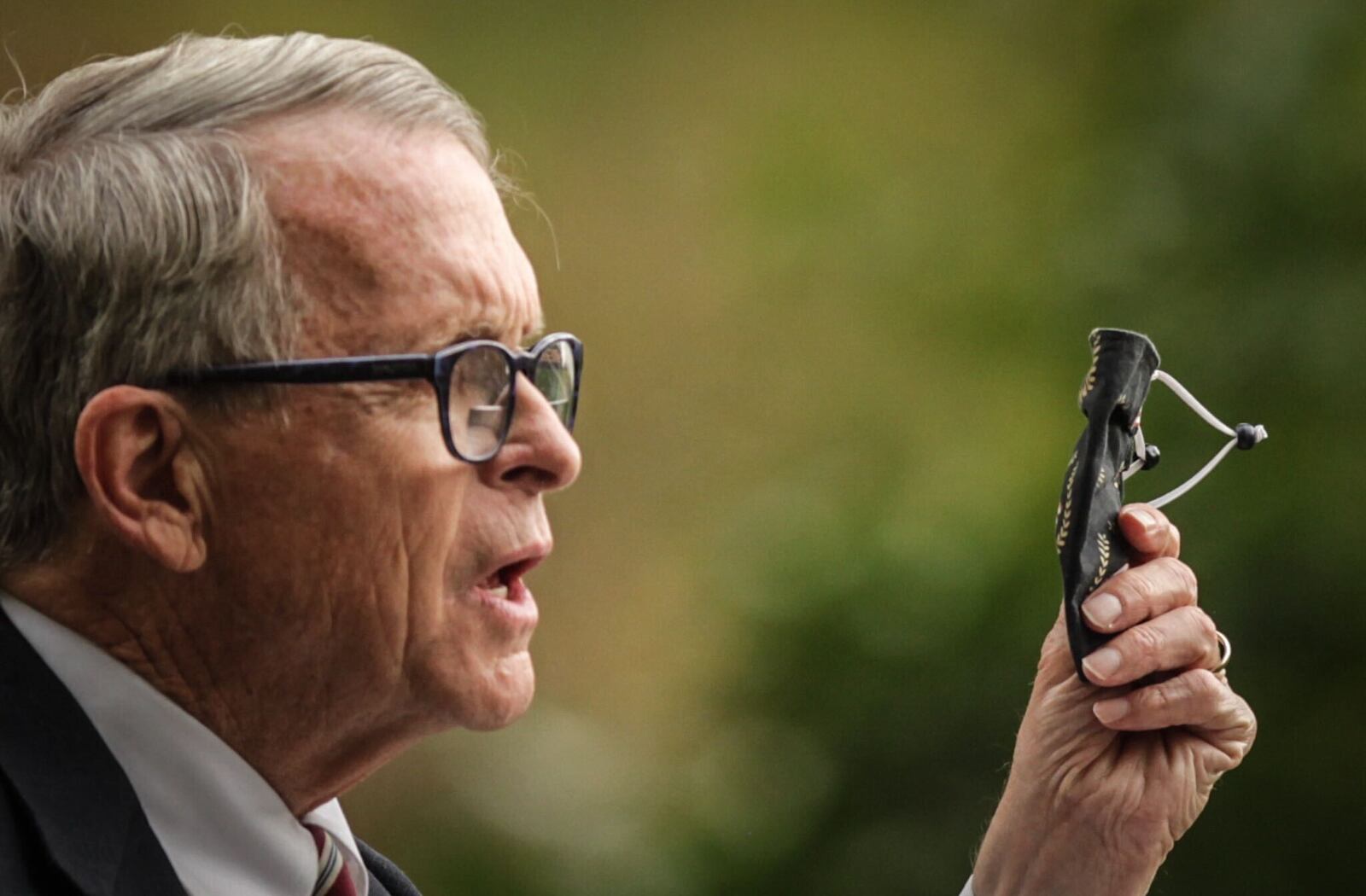 Ohio Gov. Mike DeWine holds up a mask, urging Ohioans to wear them, during a news conference Friday, Oct. 9, 2020, at the Patterson Homestead in Dayton, the same day Ohio set a daily case record of more than 1,800 COVID-19 cases. JIM NOELKER/STAFF